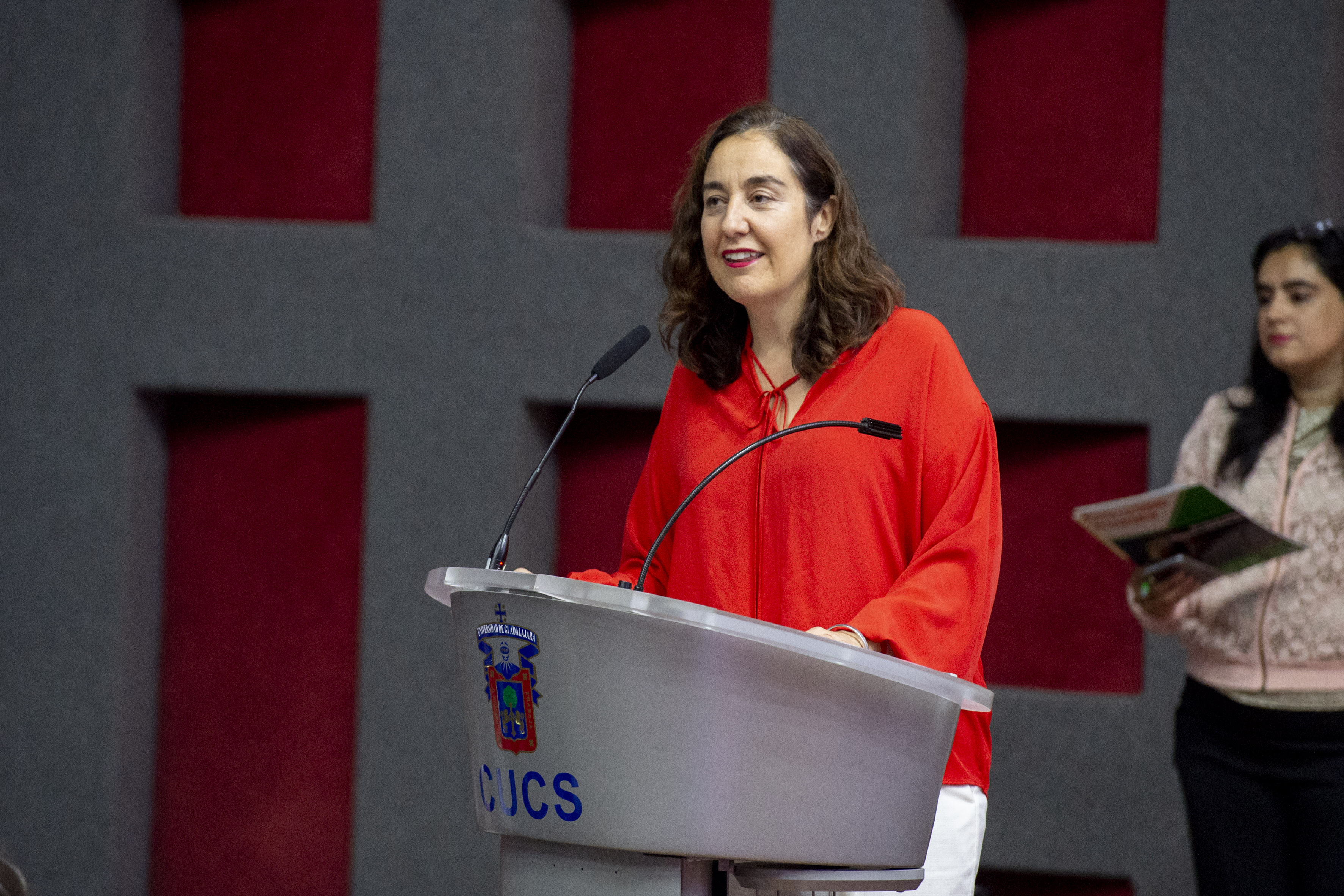 Dra Bárbara Vizmanos al micrófono en el podio