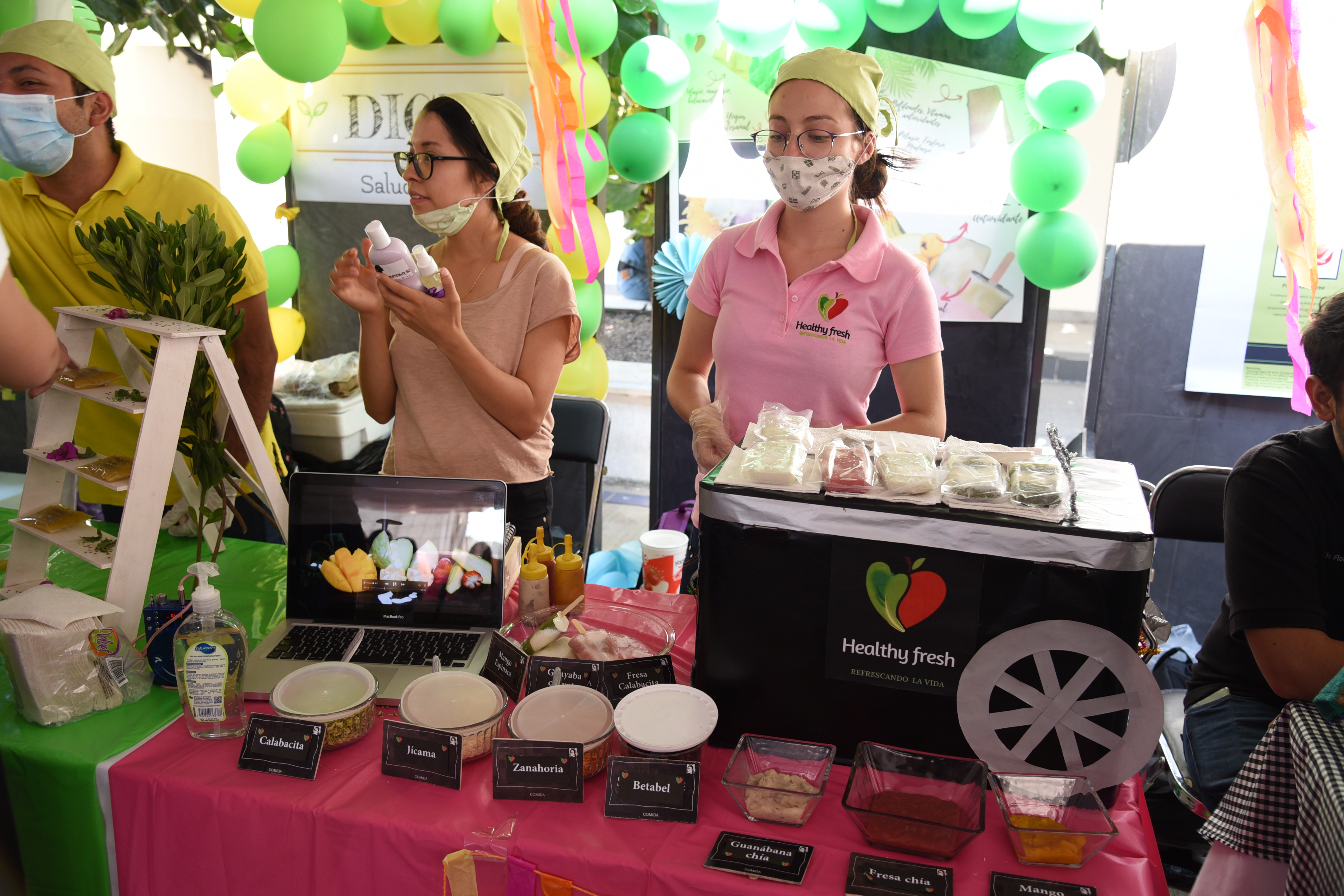 Alumnas exhibiendo en stand paletas de hielo con novedosos aderesos