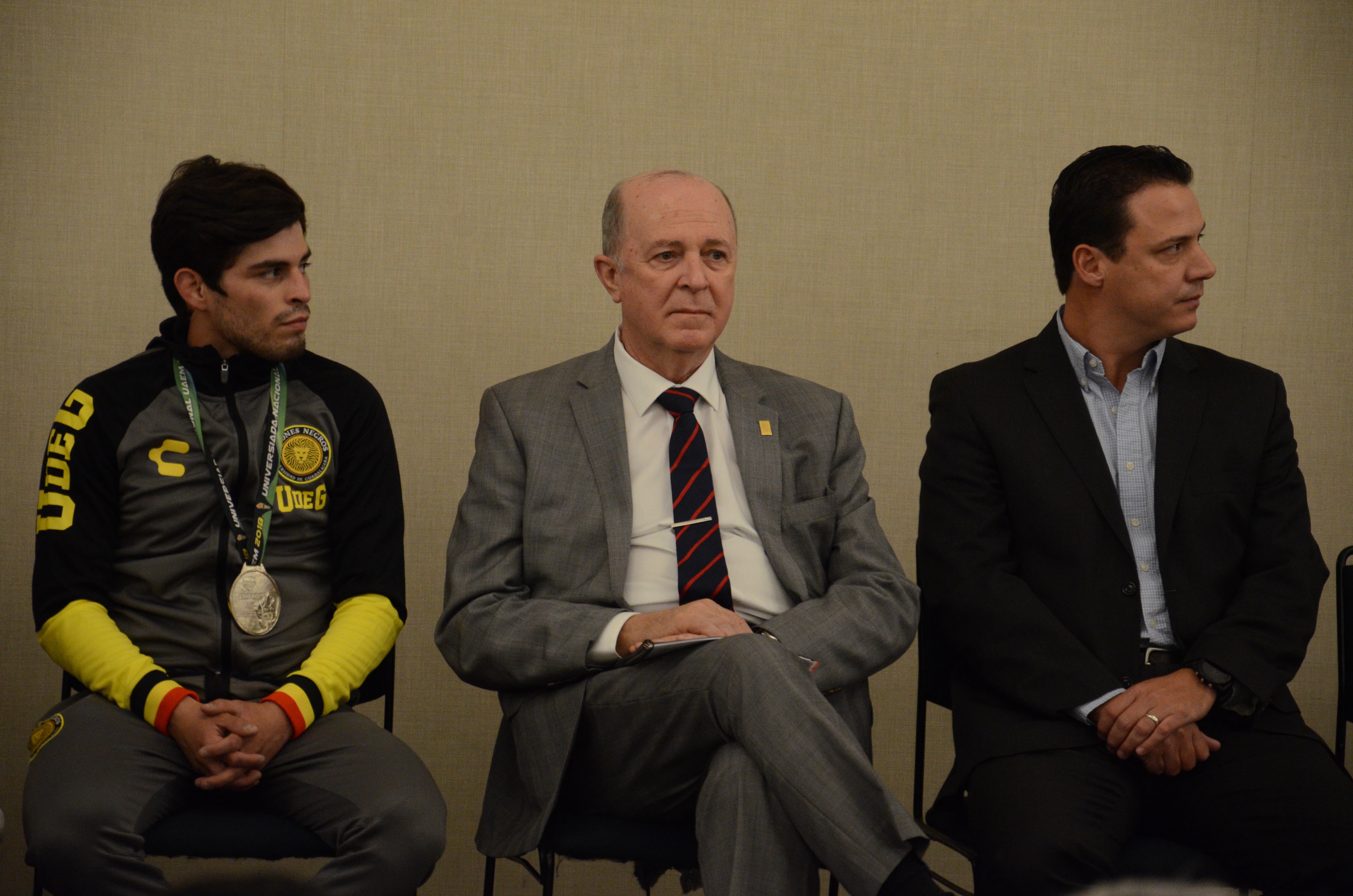 Rector General a su izquierda el director general del Code y a su derecha alumna medallista del CUCEA