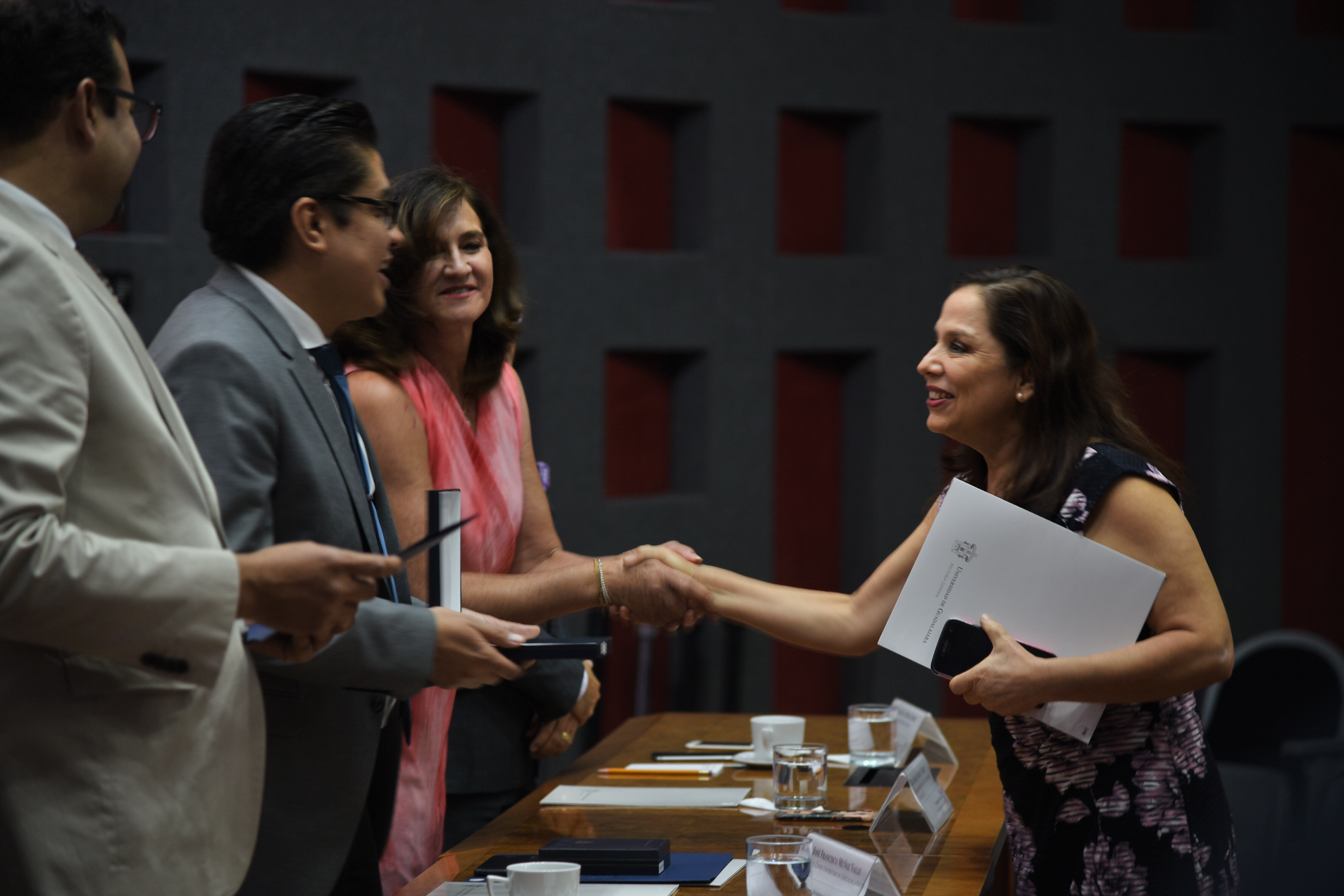 Rector del CUCS entregando reconocimiento a docente 