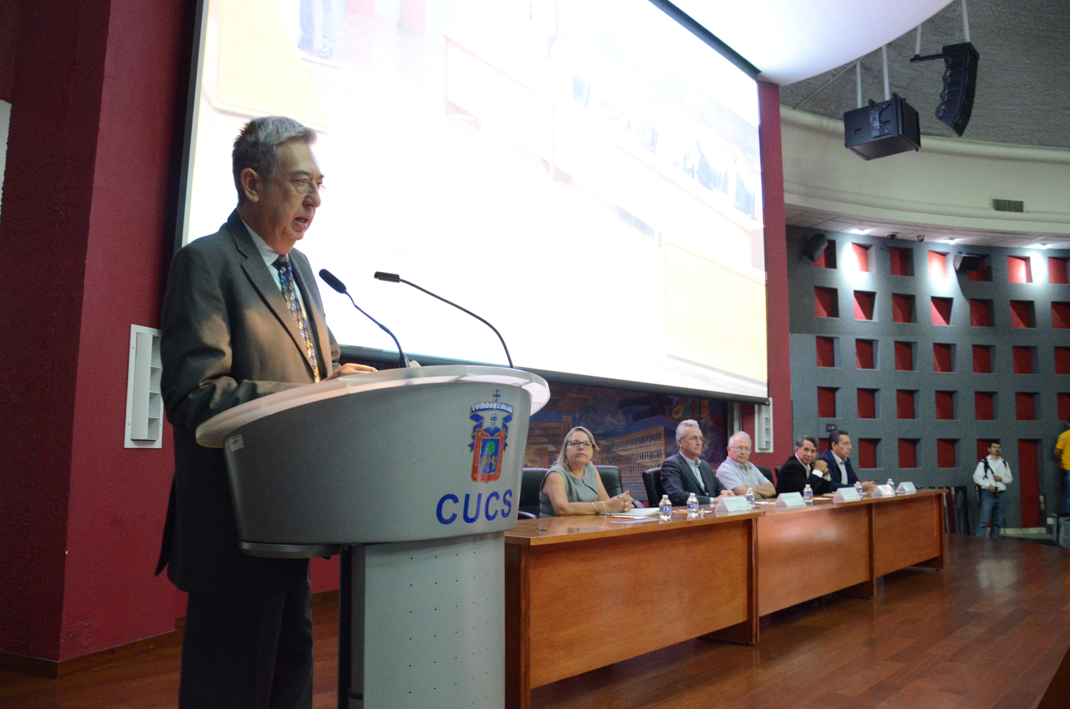Secretario Académico del CUCS dando lectura al CV del secretario de Salud