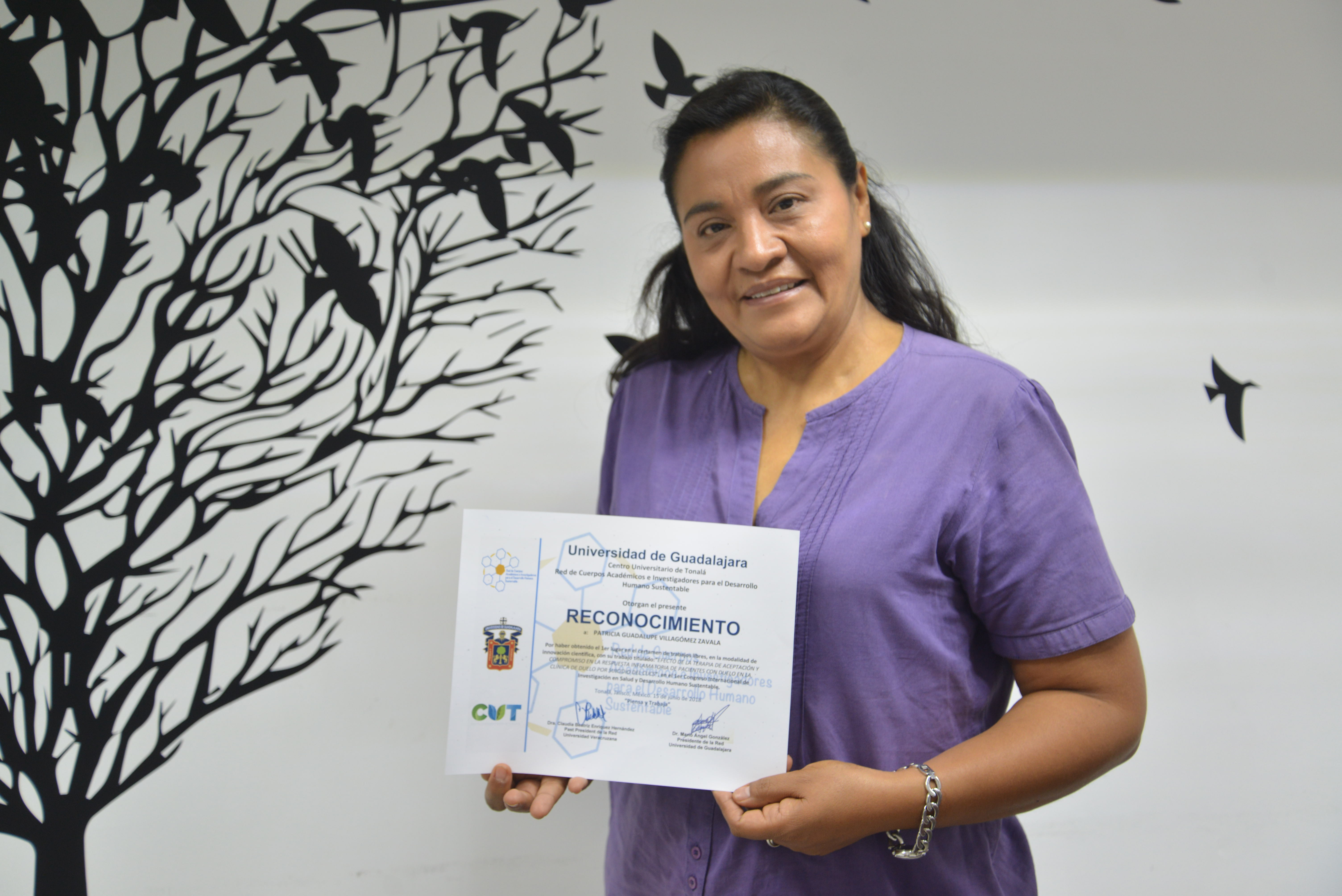 Dra Paty Villagómez mostrando el reconocimiento