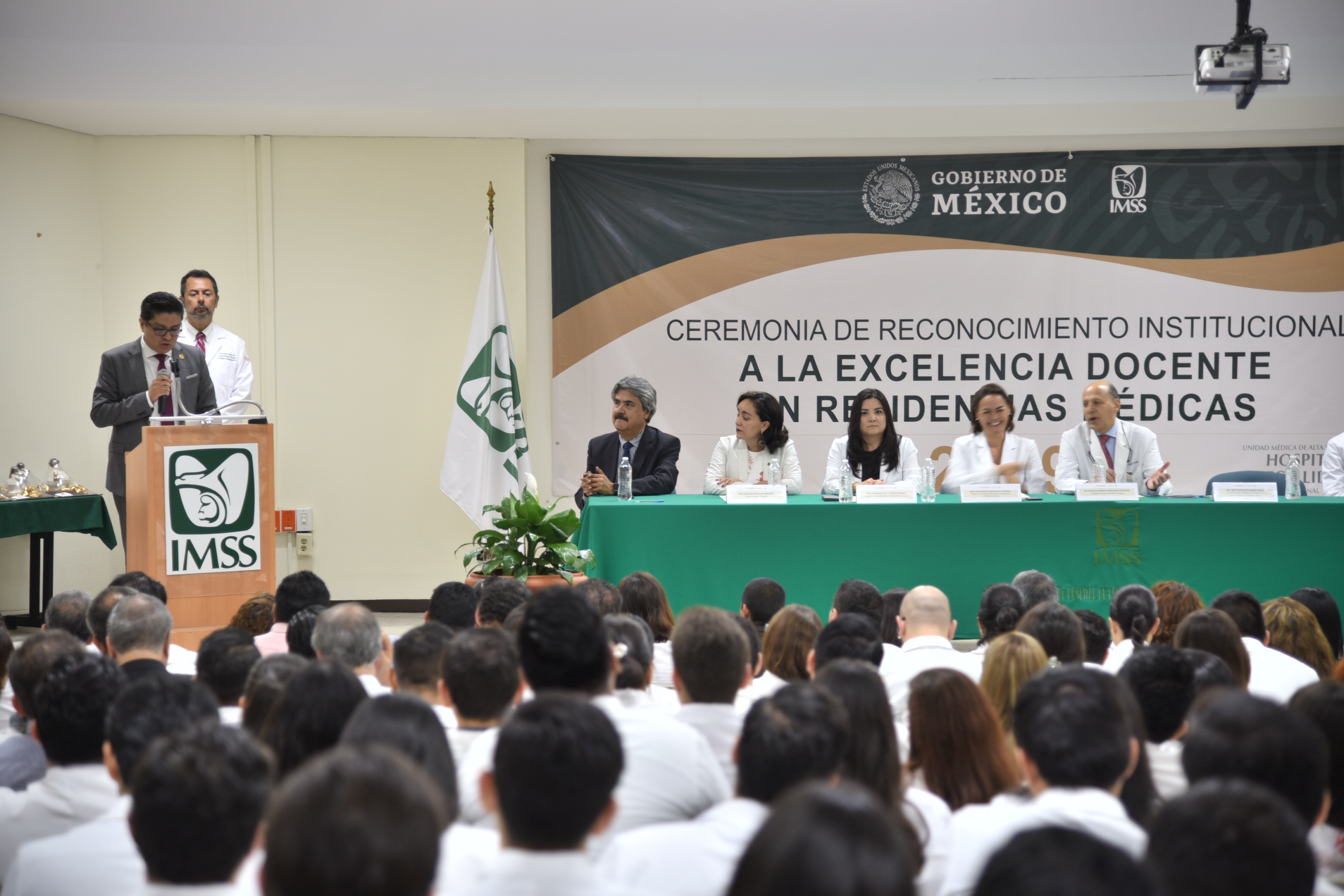 Rector CUCS dando mensaje ante docentes del IMSS, toma general desde el fondo del auditorio