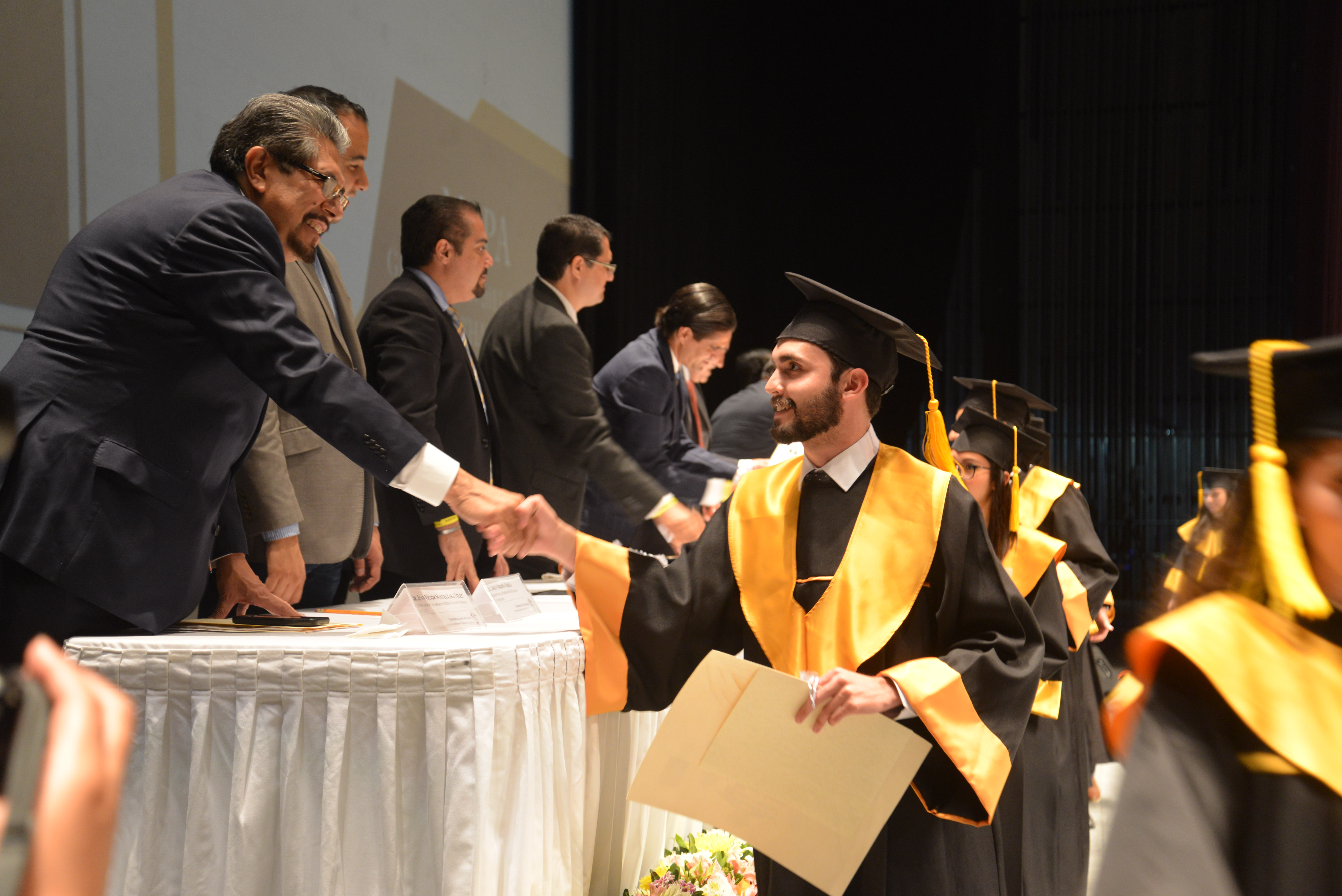 Alumno graduado recibiendo diploma