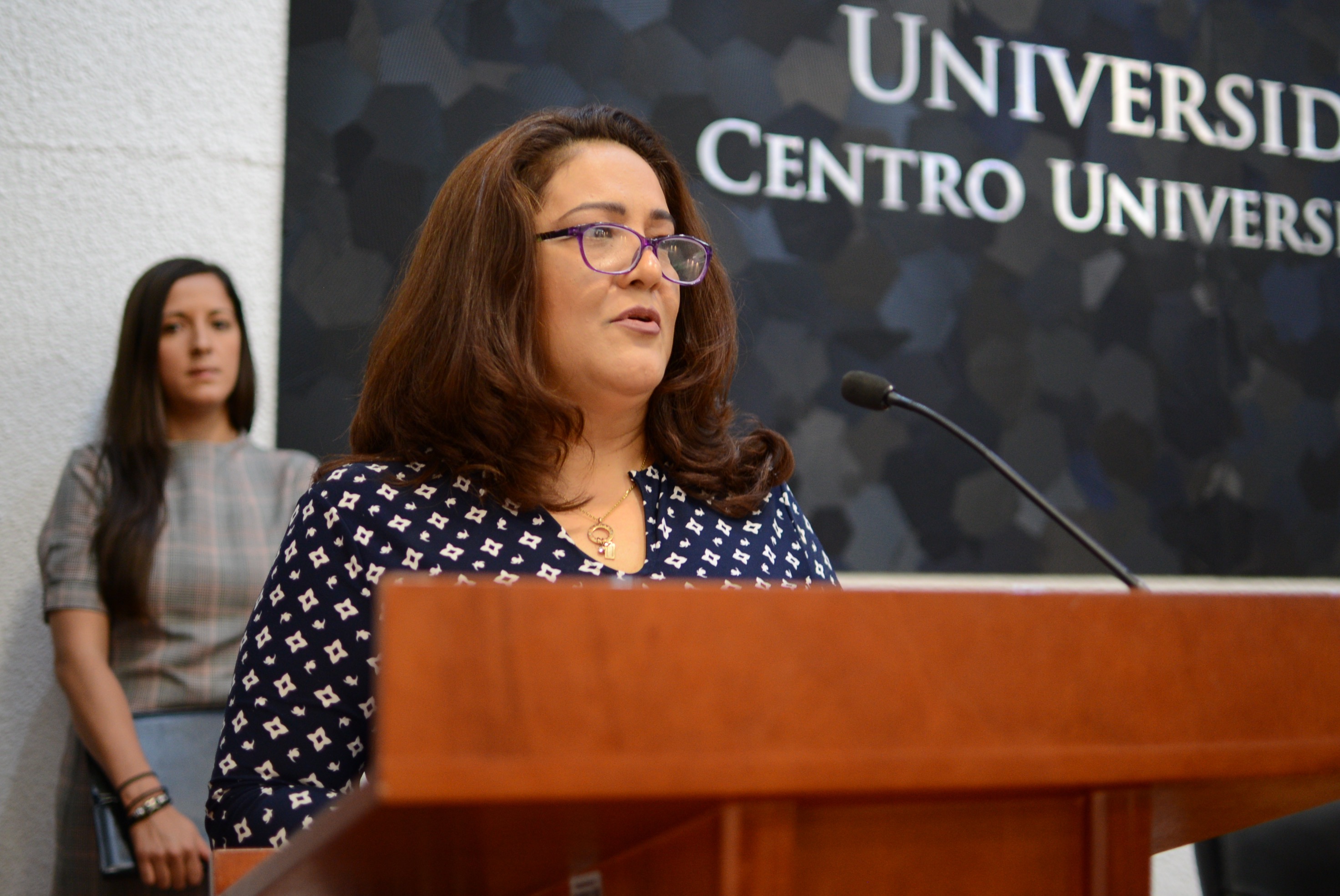 Lic. María Dolores Villegas, representante de los galardonados, ofreciendo mensaje en pódium