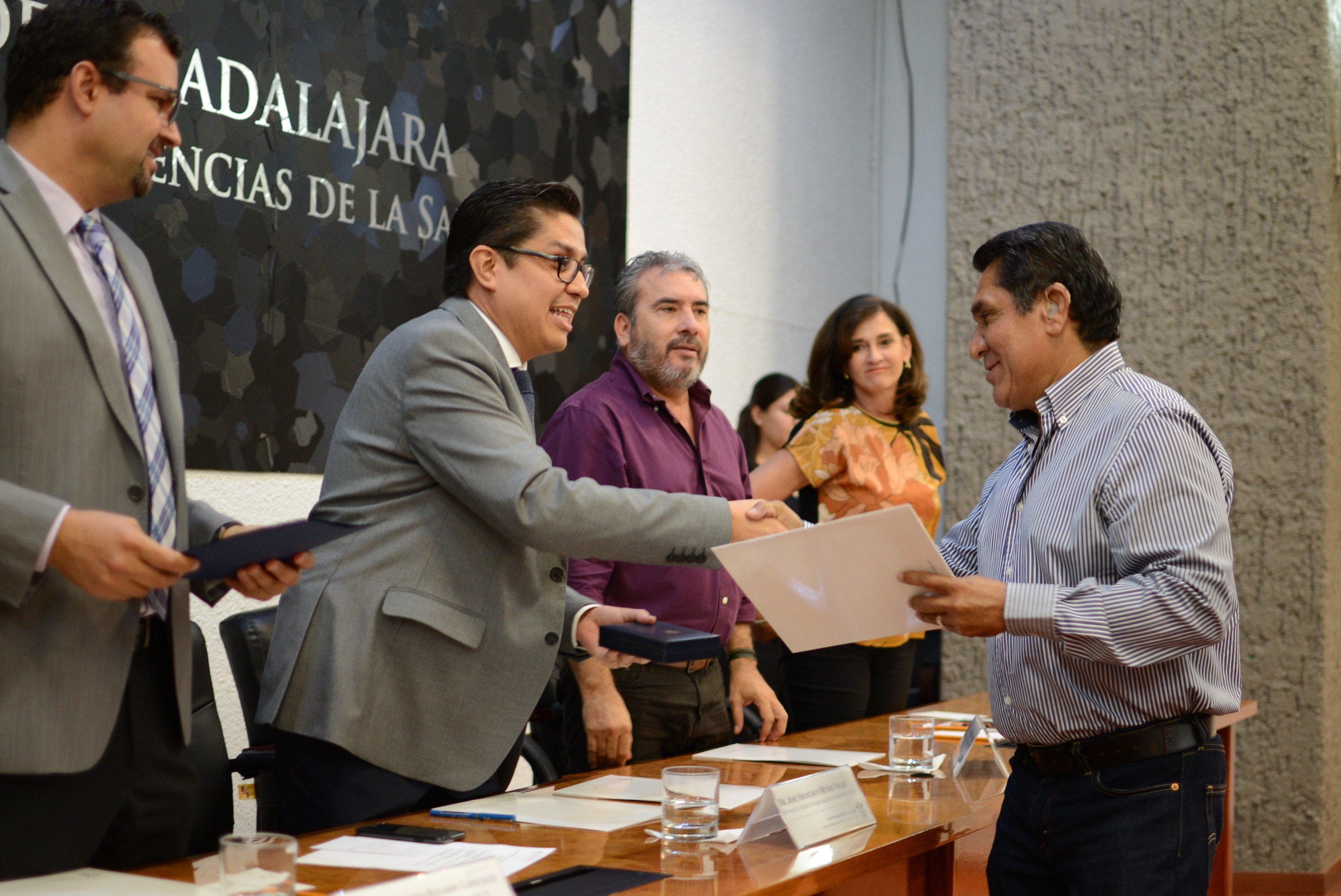 Rector del CUCS entregando reconocimiento