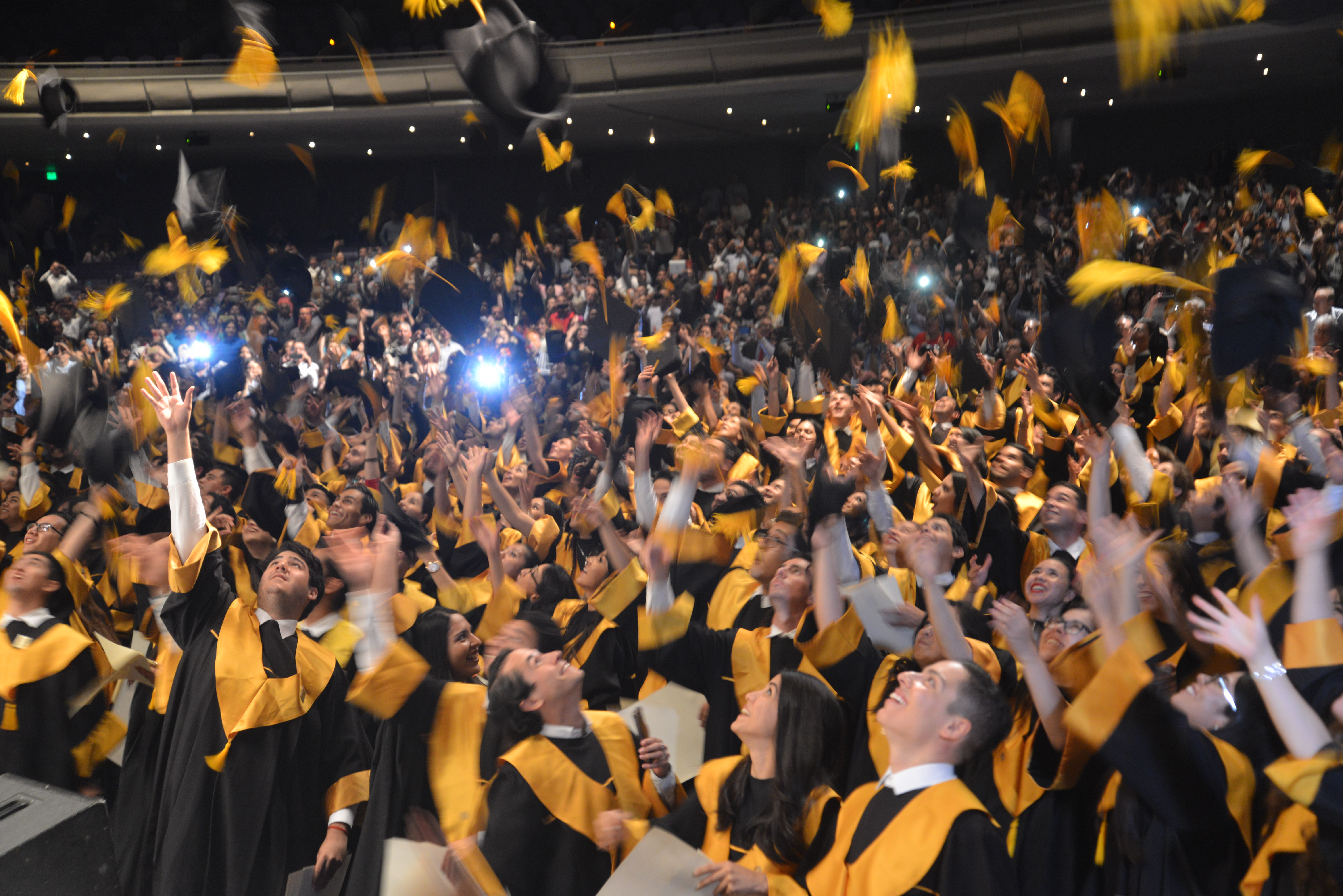 Alumnos graduados lanzando el birrete