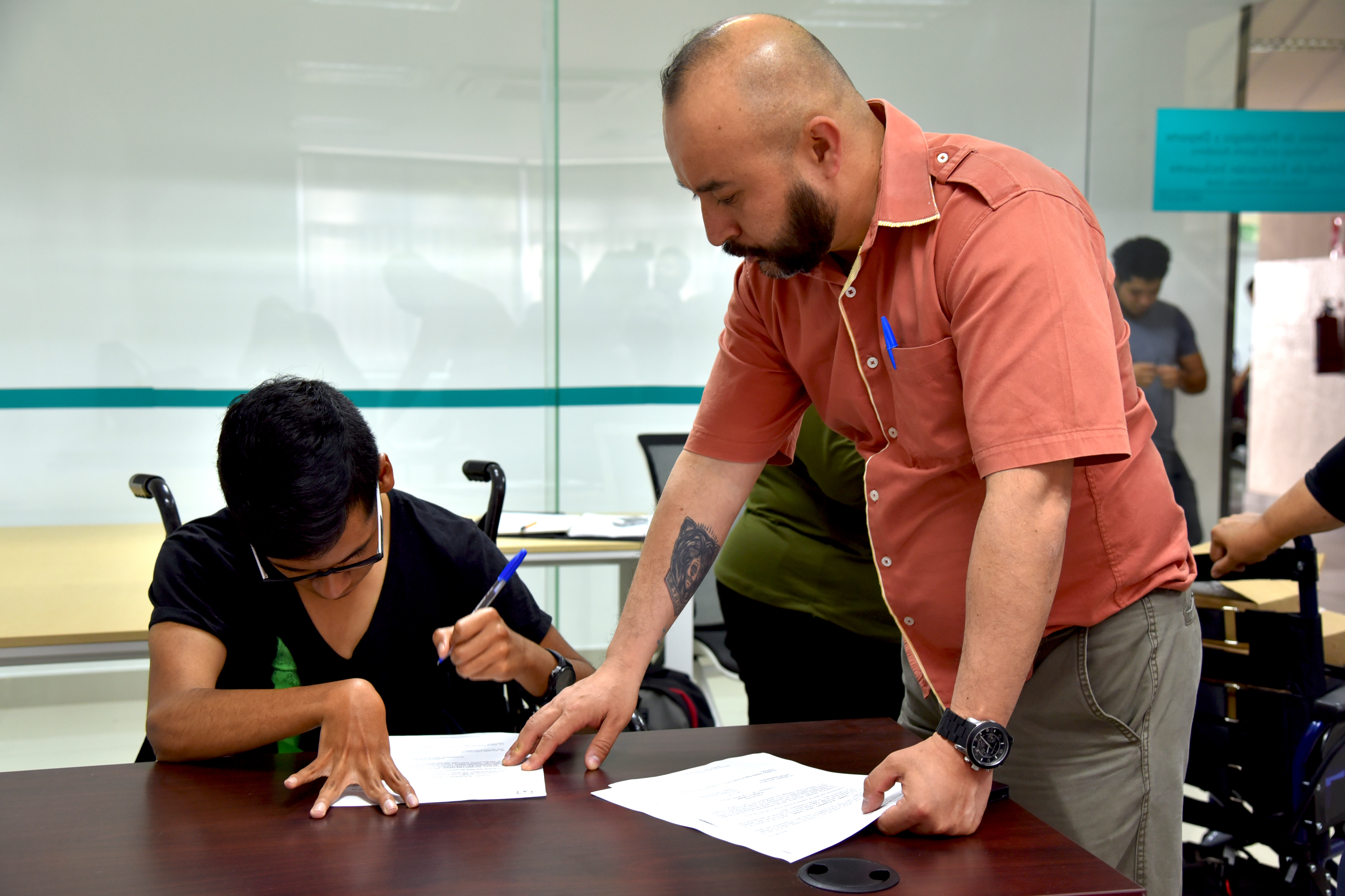 Daniel Cruz Alumno beneficiado firmando documentos