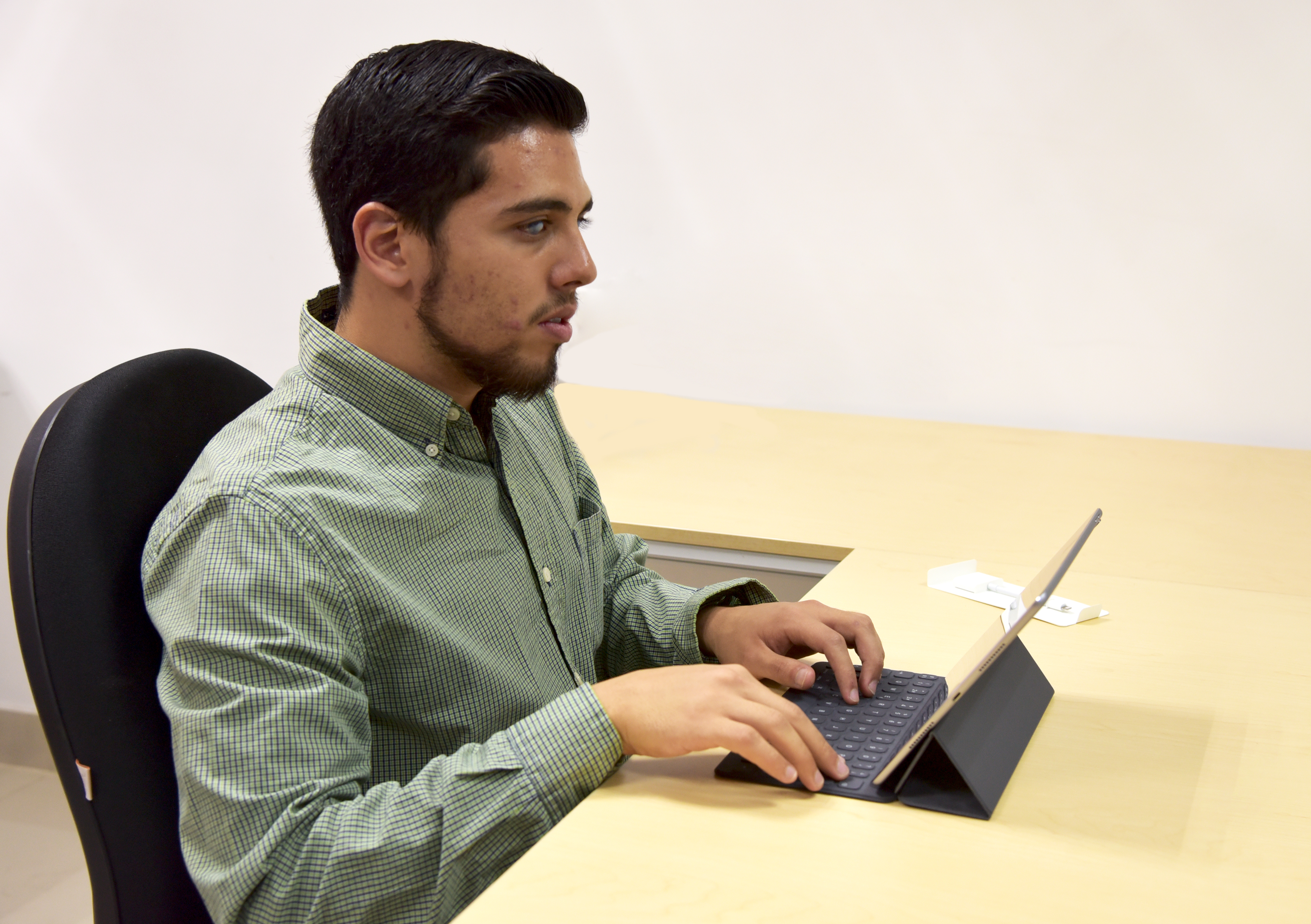 Martín Cortés, sentado usando su iPad
