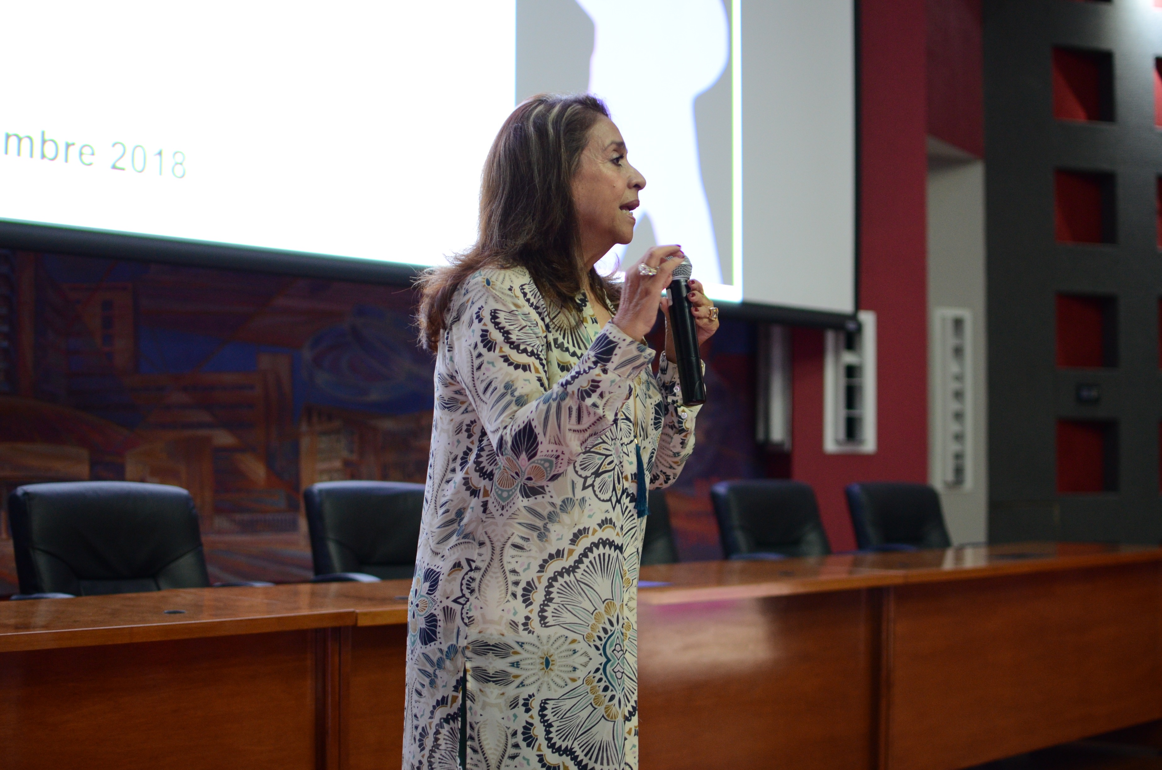 Dra. Norma Quezada al micrófono dando palabras de bienvenida