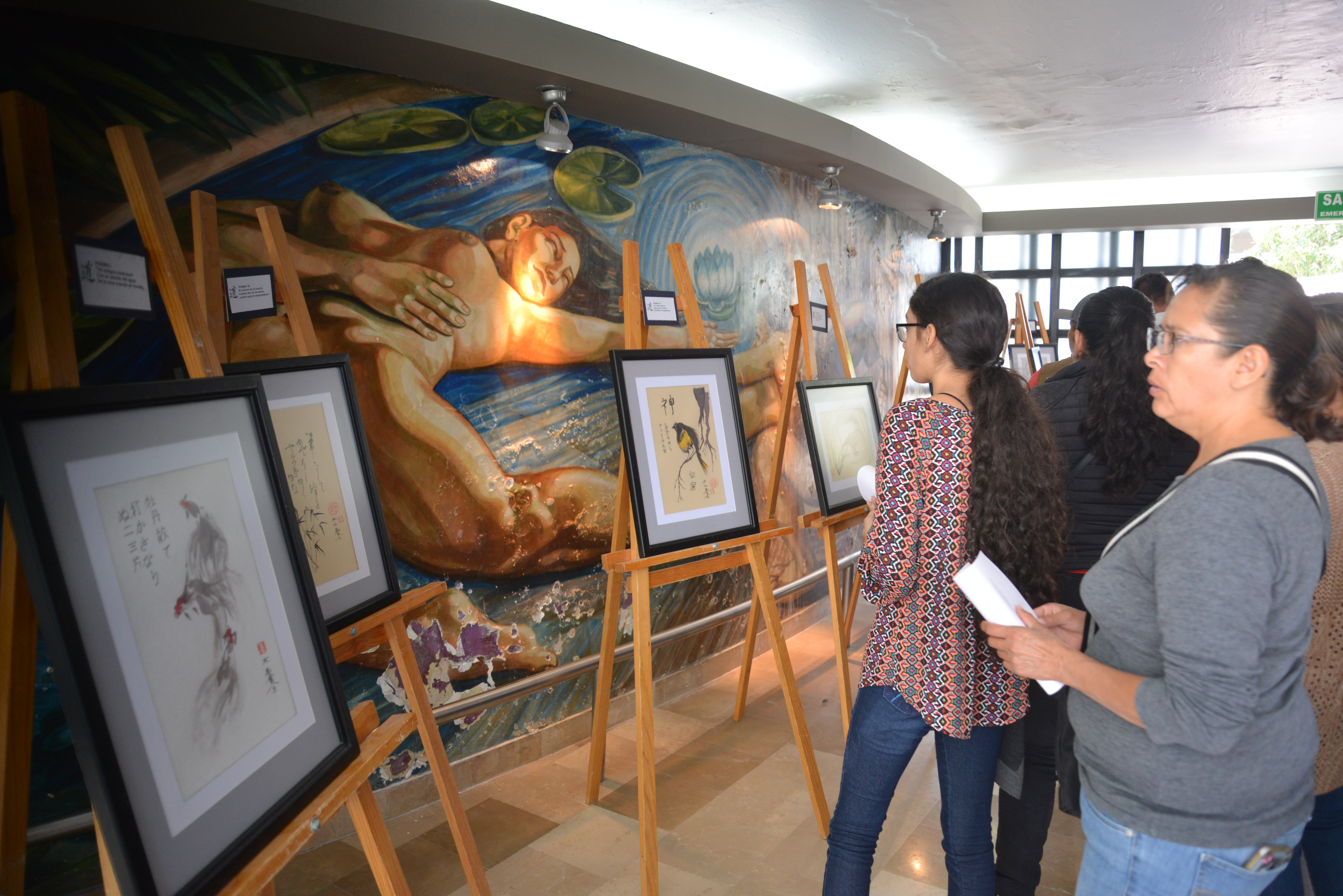 Padres de familia viendo exposición en la antesala del auditorio