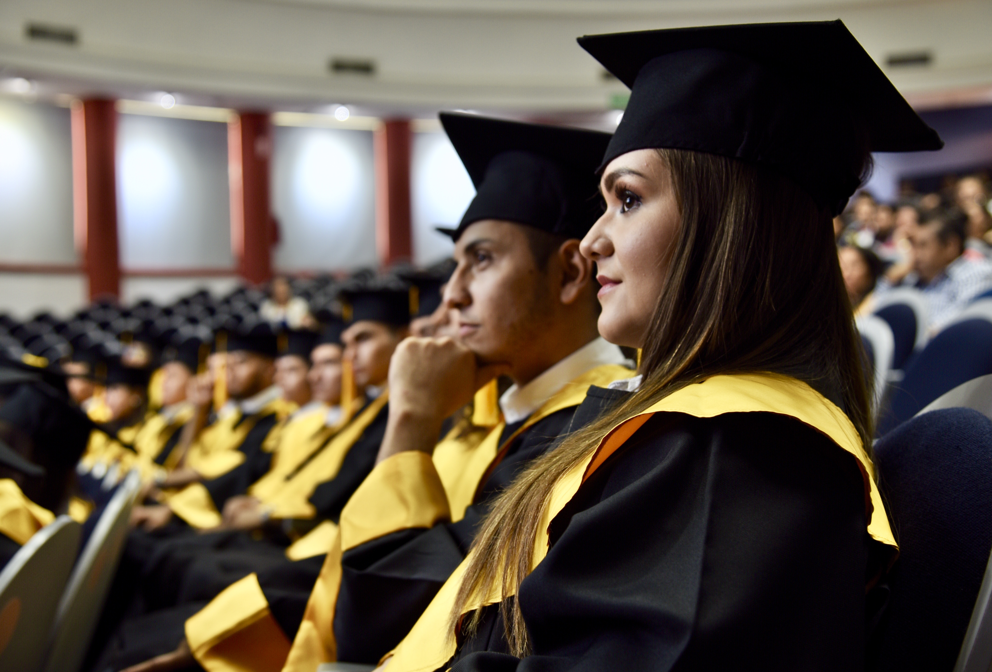 Graduados en el auditorio escuchando mensajes