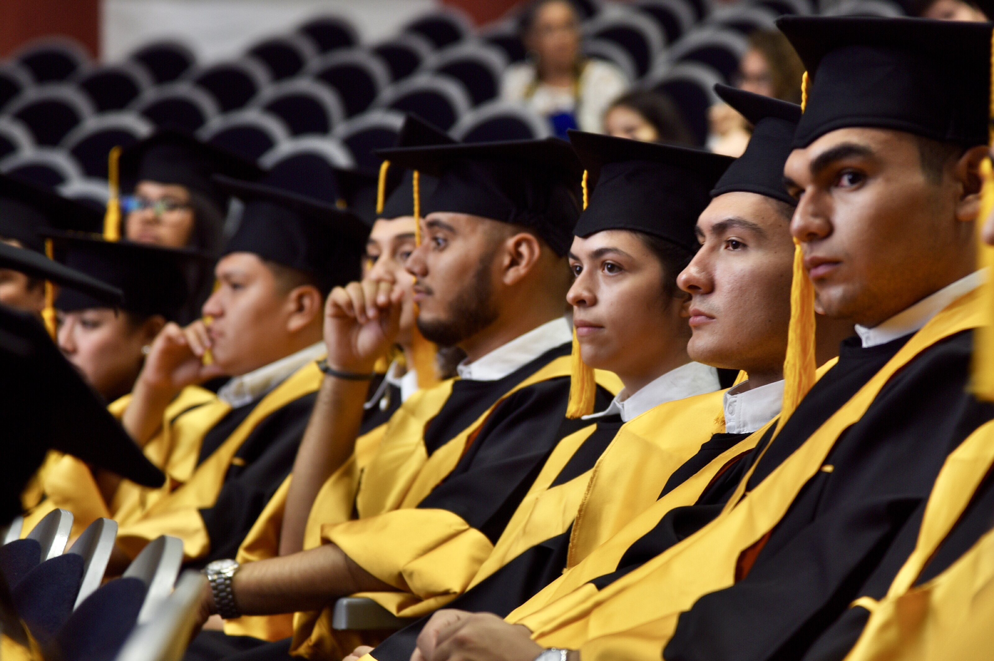 Graduados en el auditorio escuchando mensajes