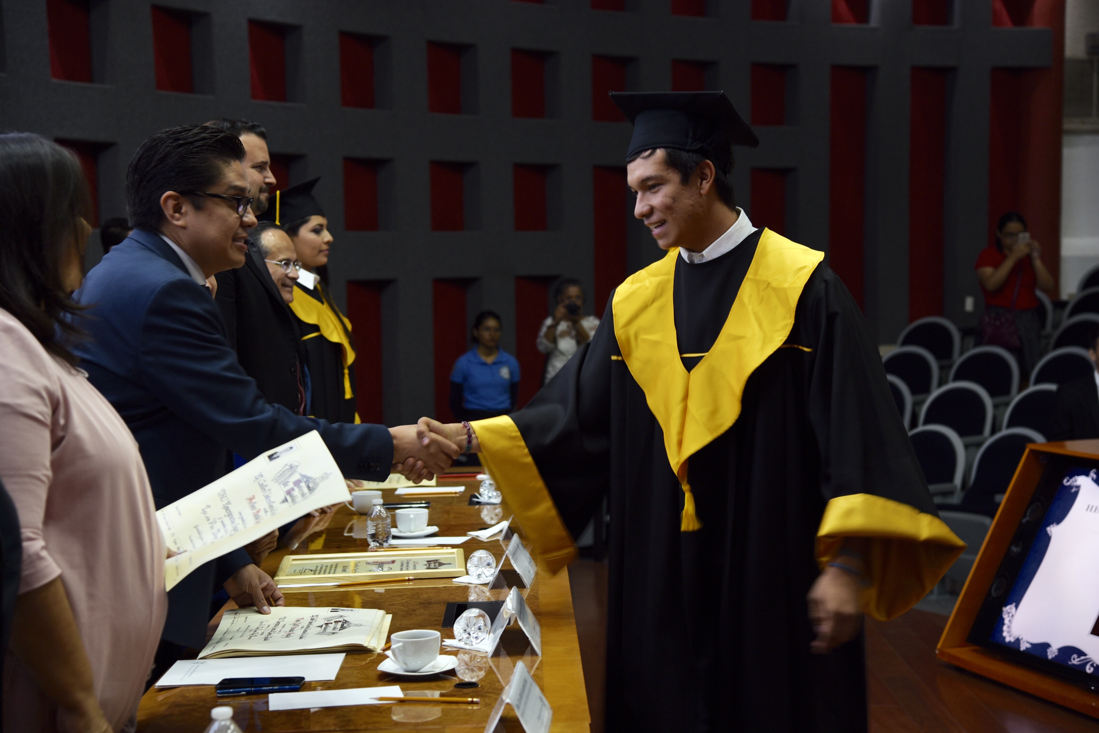 Rector CUCS entregando constancia a graduados