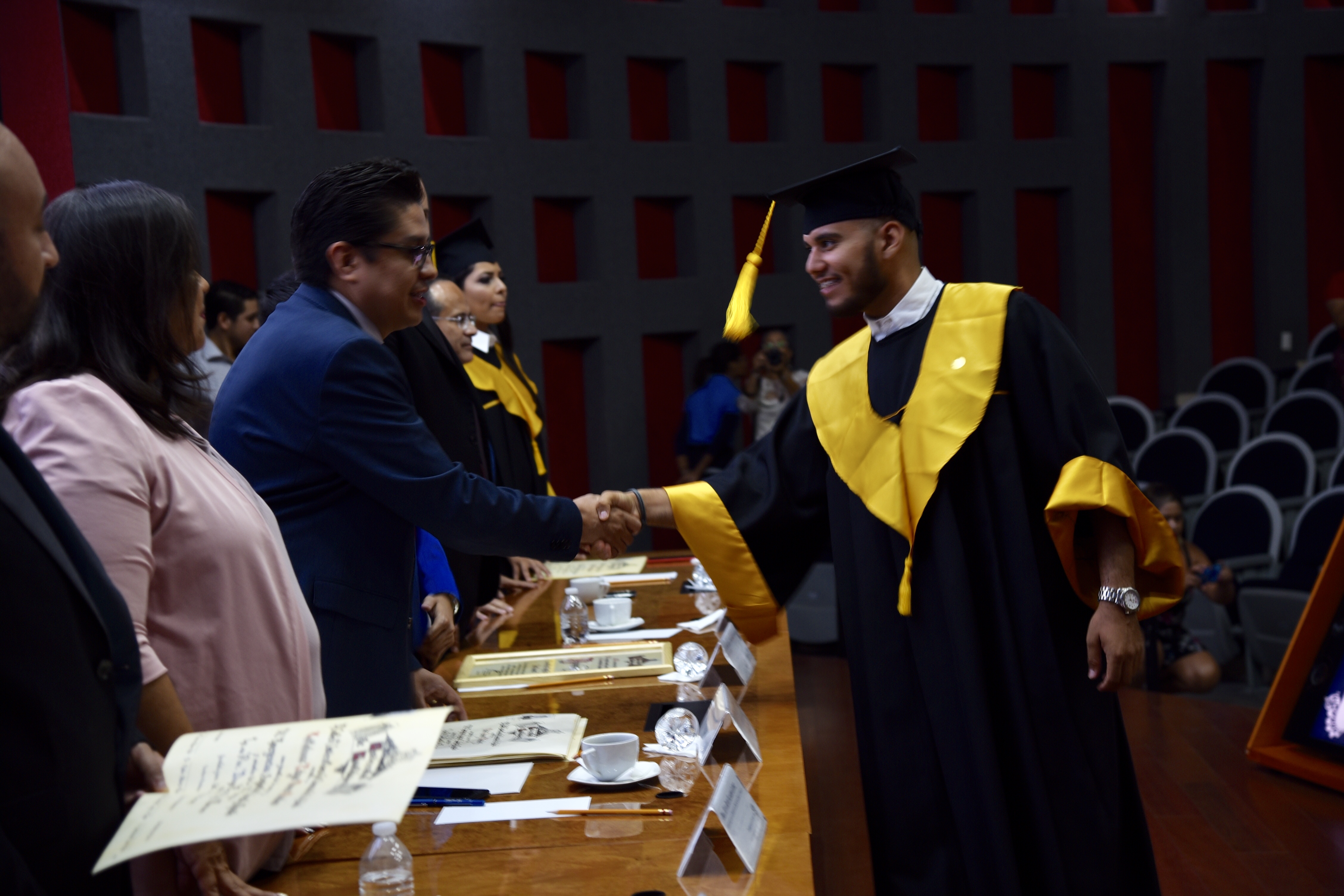 Rector CUCS entregando constancia a graduados