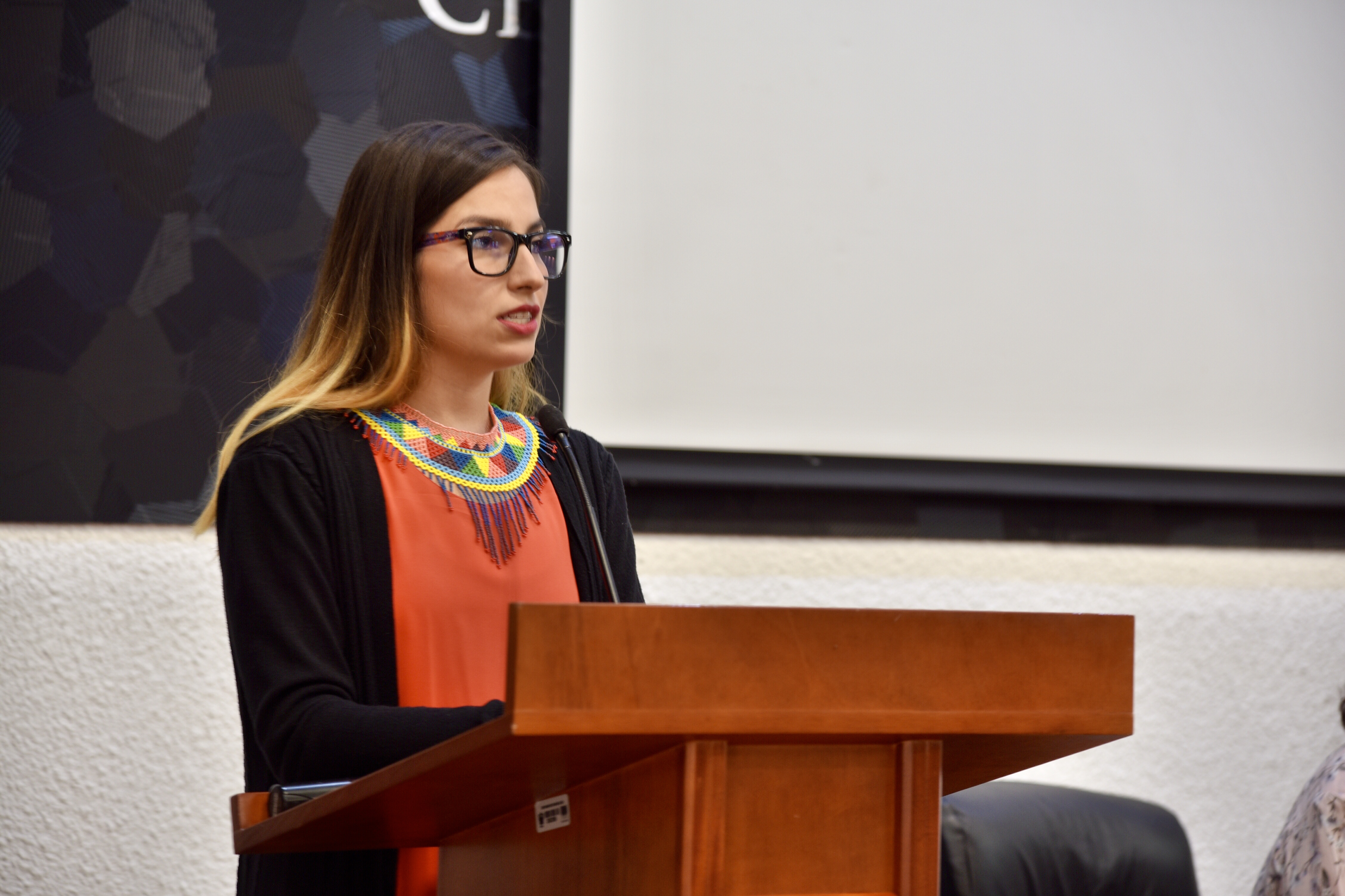 Dra. Wendy Campos dando mensaje desde el pódium