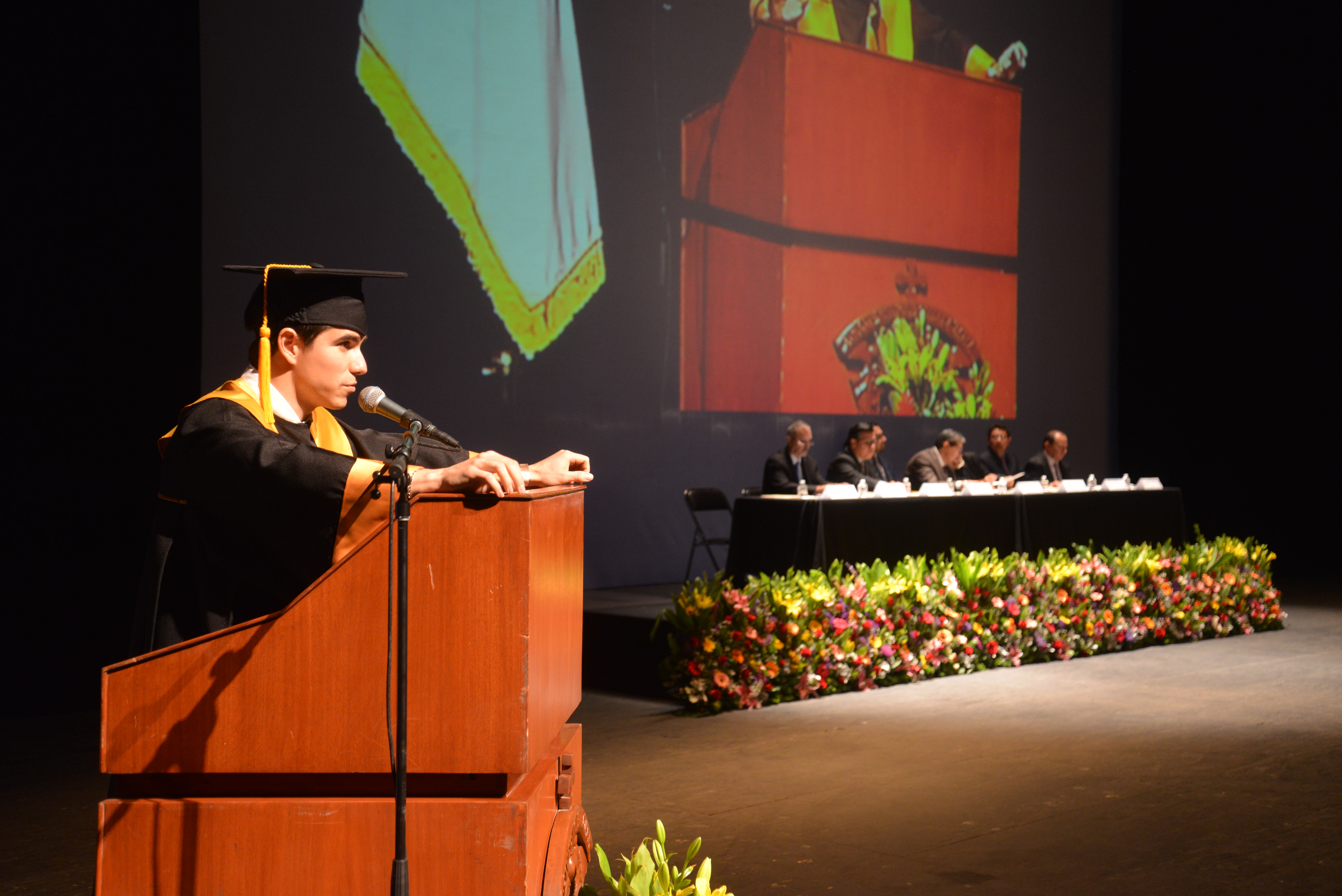 Presidente de la Sociedad de Alumnos Internos de Pregrado al micrófono en el pódium