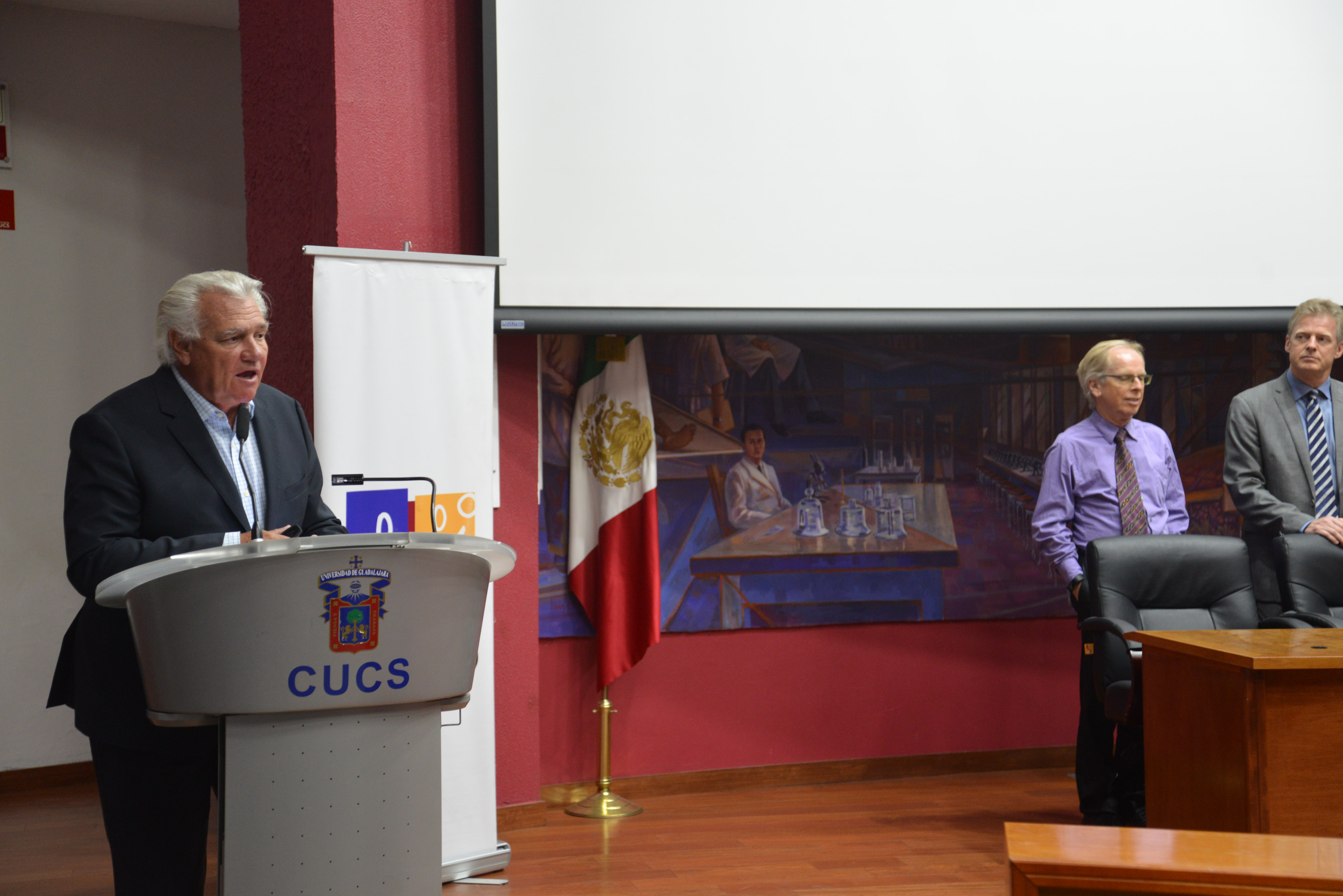 Dr. Juan López y Tyalor al micrófono en mensaje de bienvenida