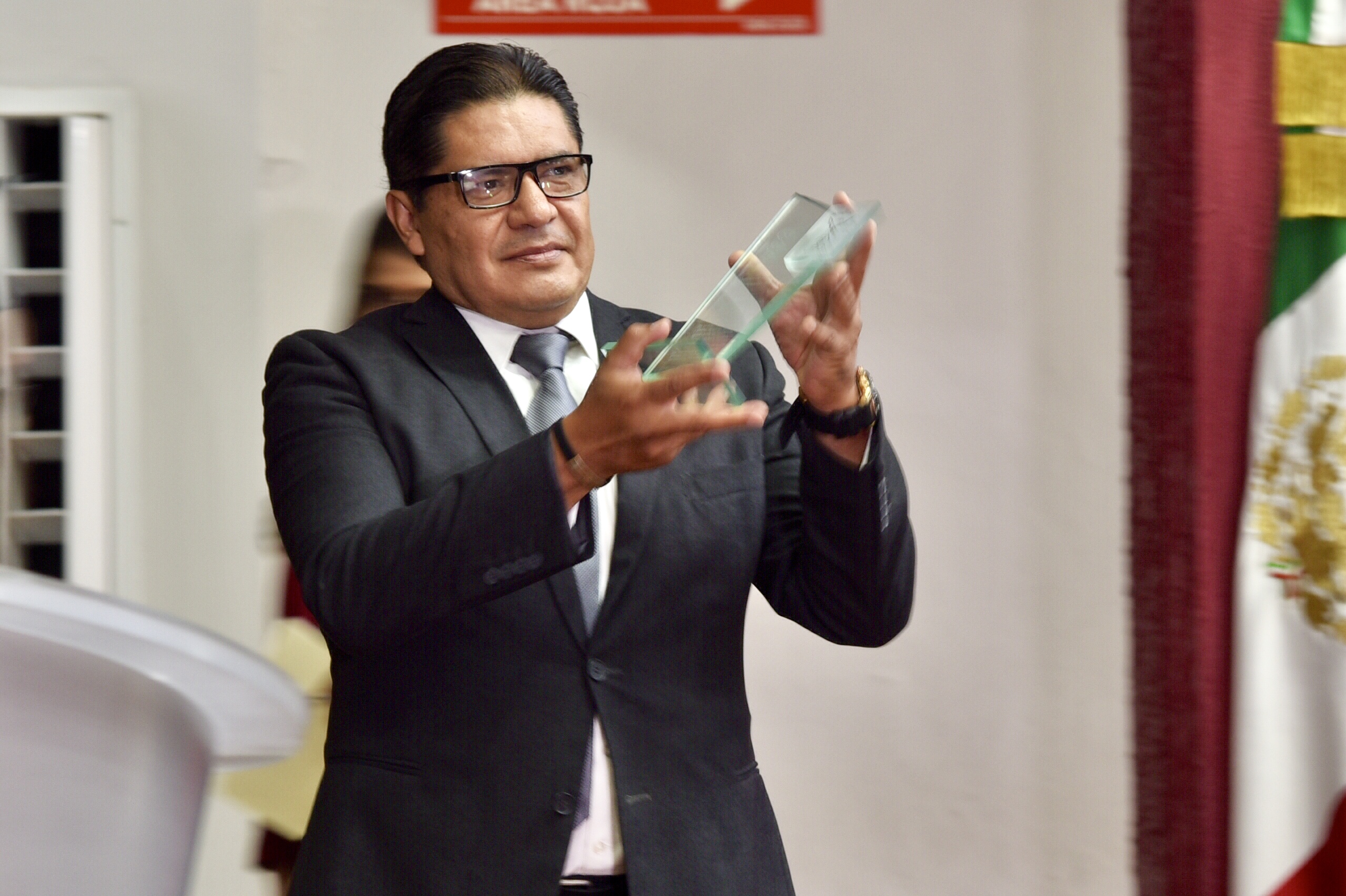 Padrino de graduados alzando su reconocimiento