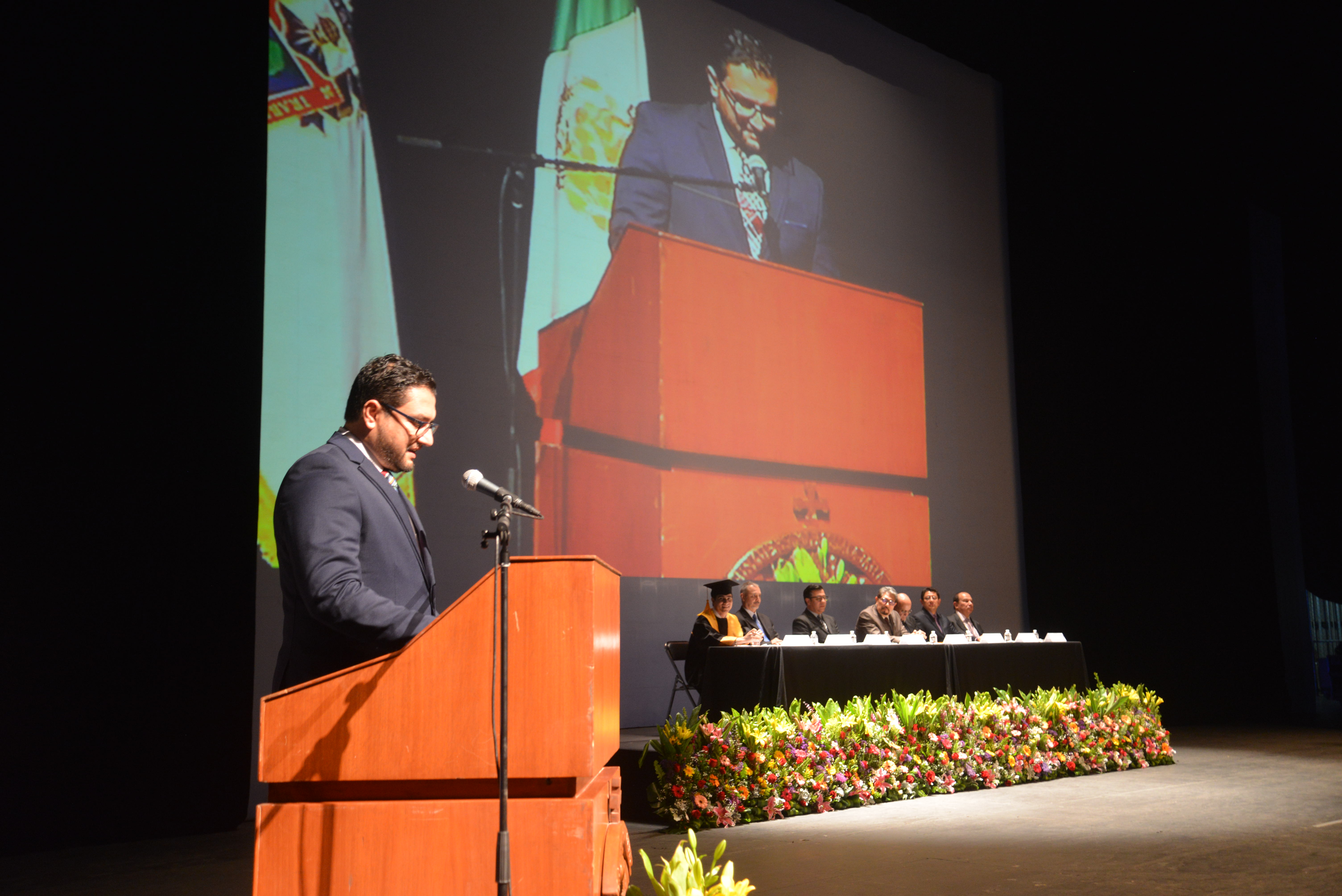 Padrino de generación dando su mensaje en el pódium