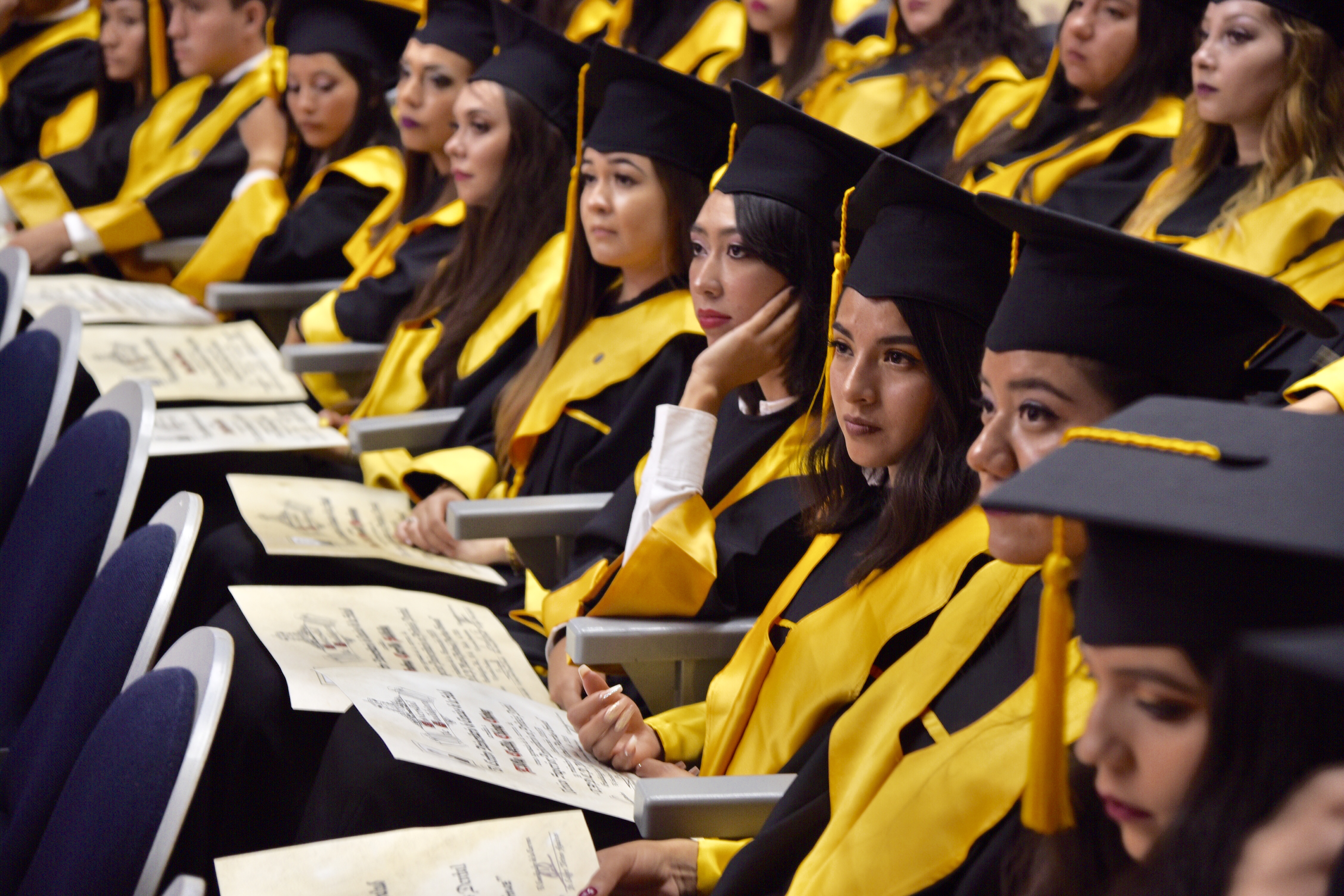 Foto de graduados sentados en sus butacas