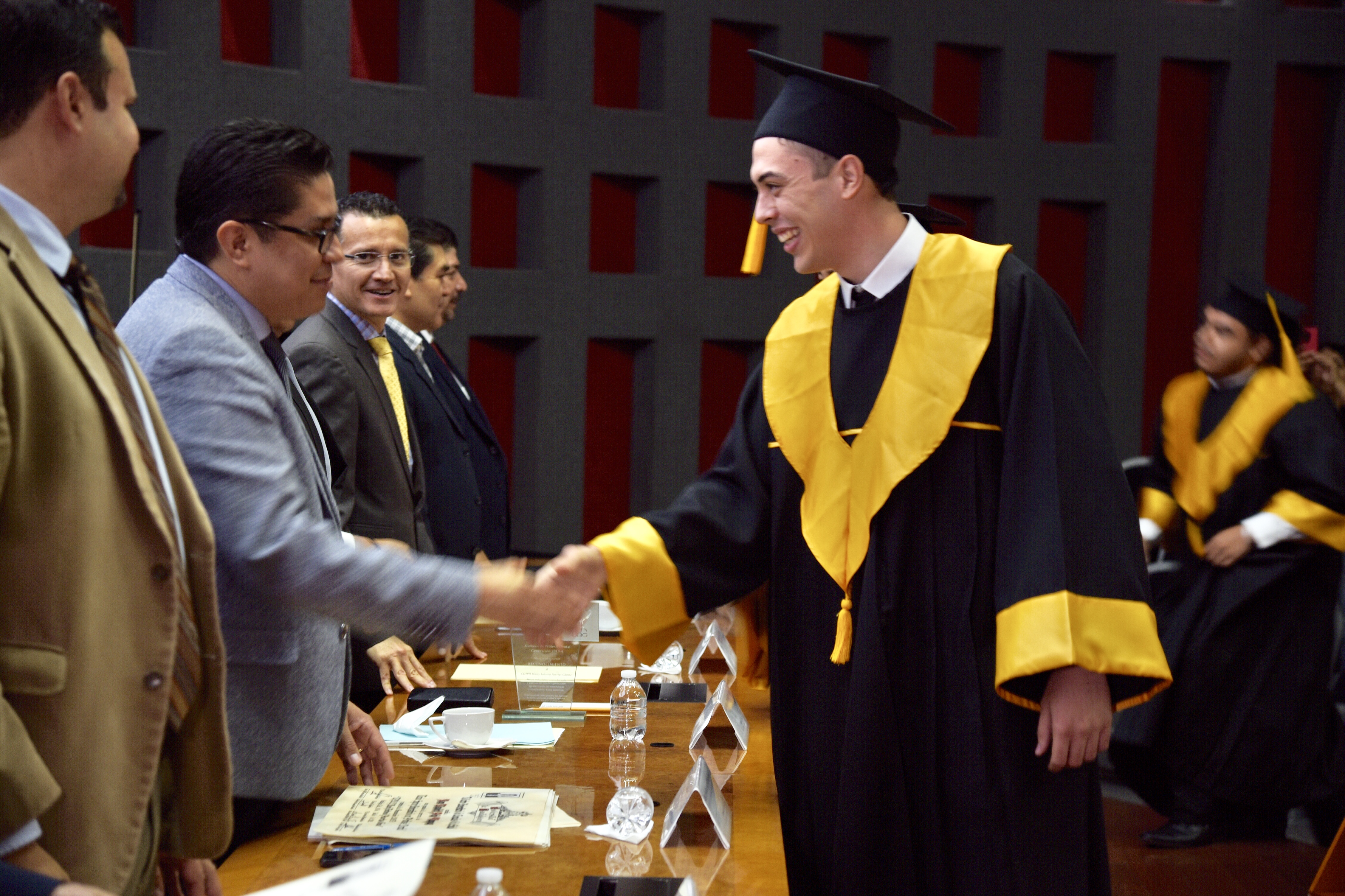 Rector del CUCS entregando constancia de egresado a graduado