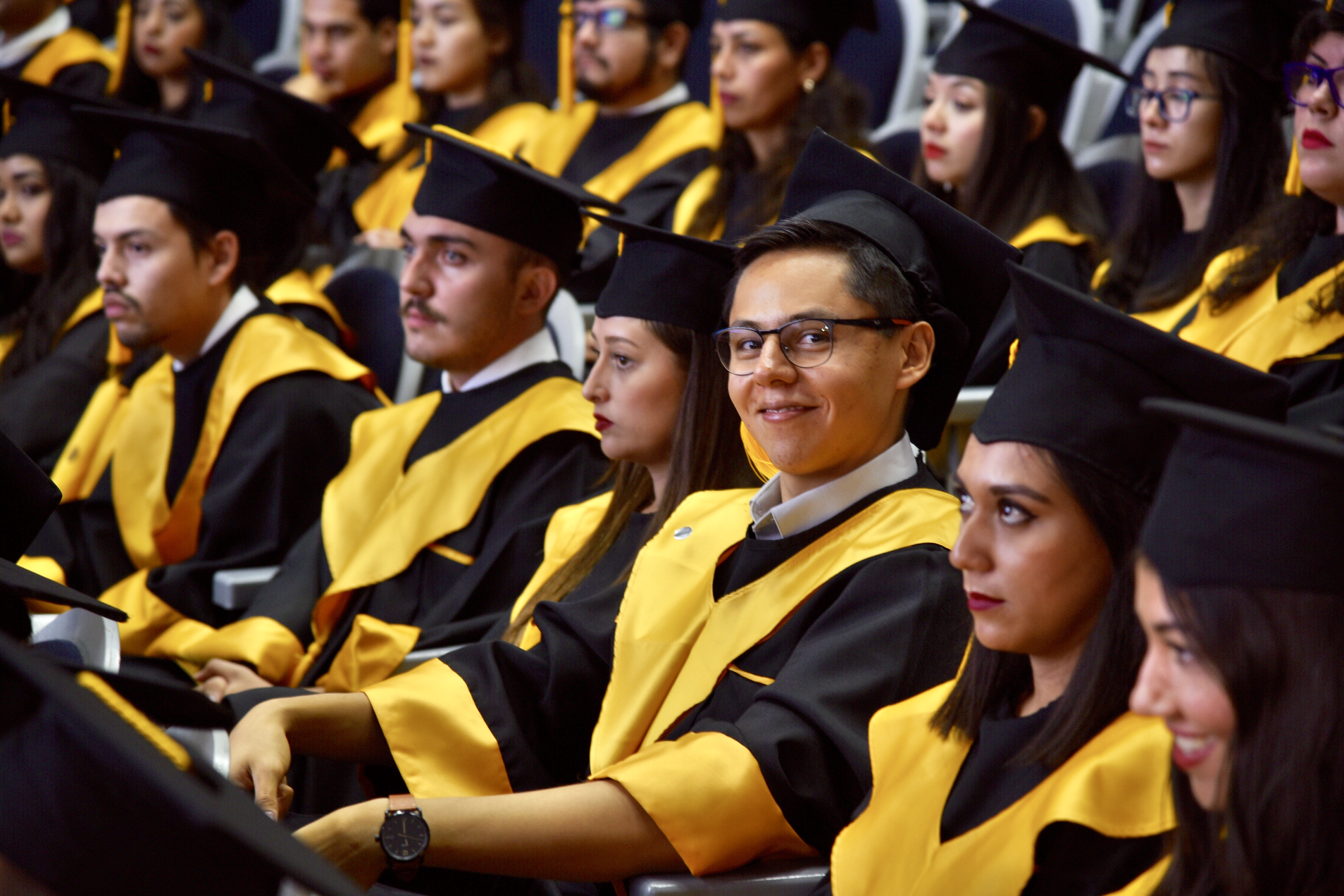 Alumnos graduados sentados en sus butacas