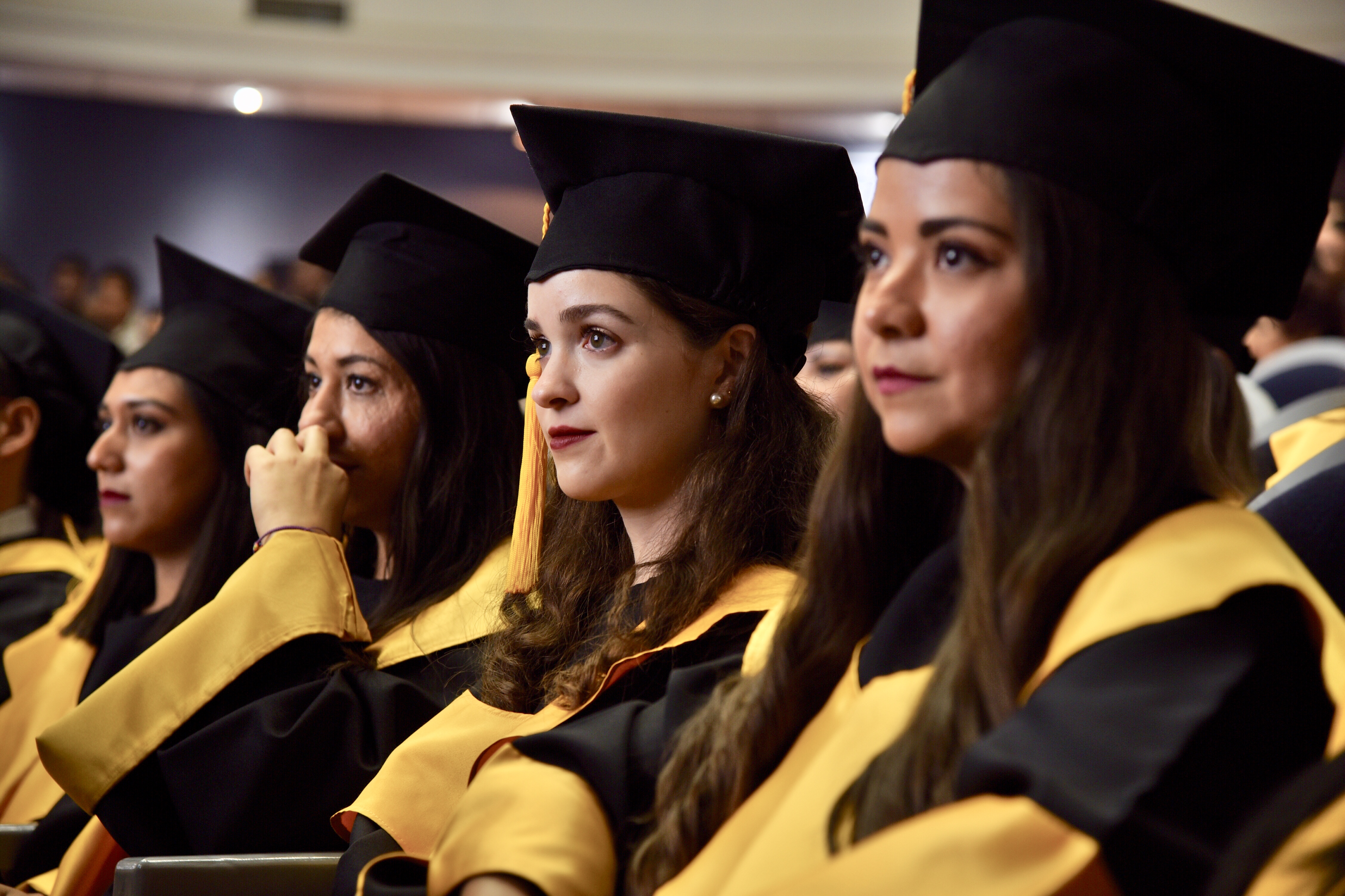 Alumnas graduadas sentadas en sus butacas