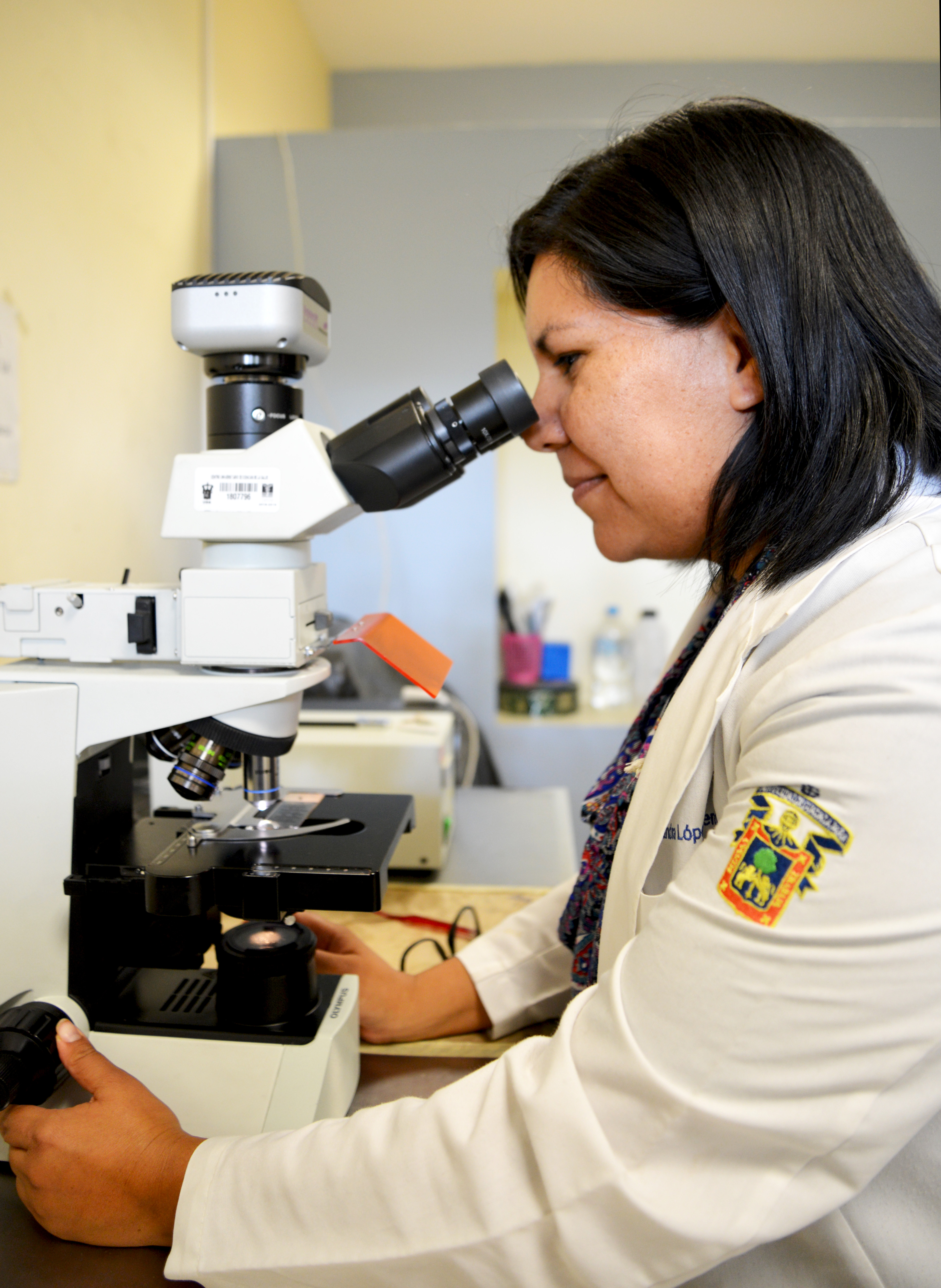 Dra. López Verdín mirando a través del microscopio