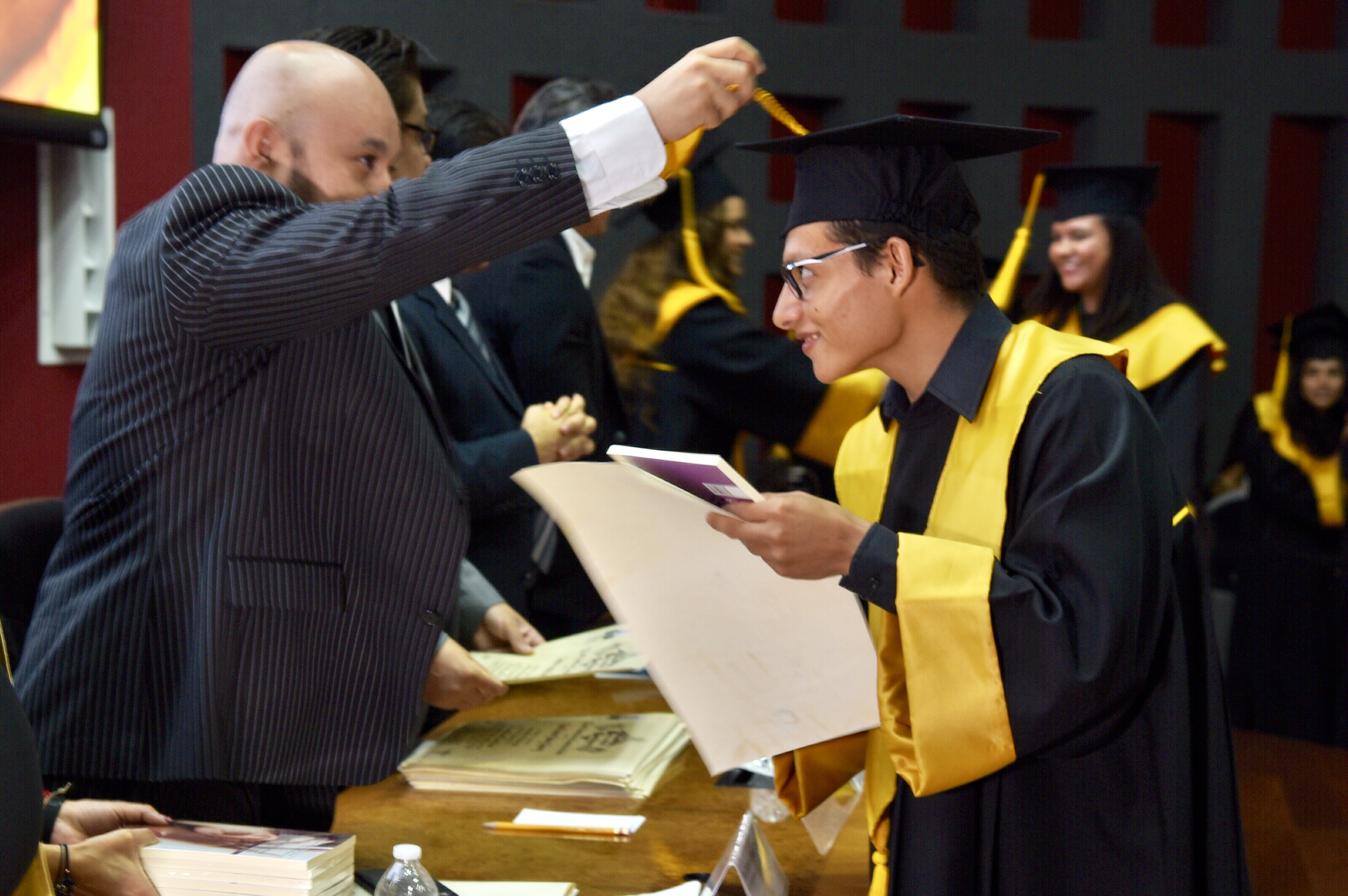 Padrino de Generación cambiando la mota del birrete de su ahijado