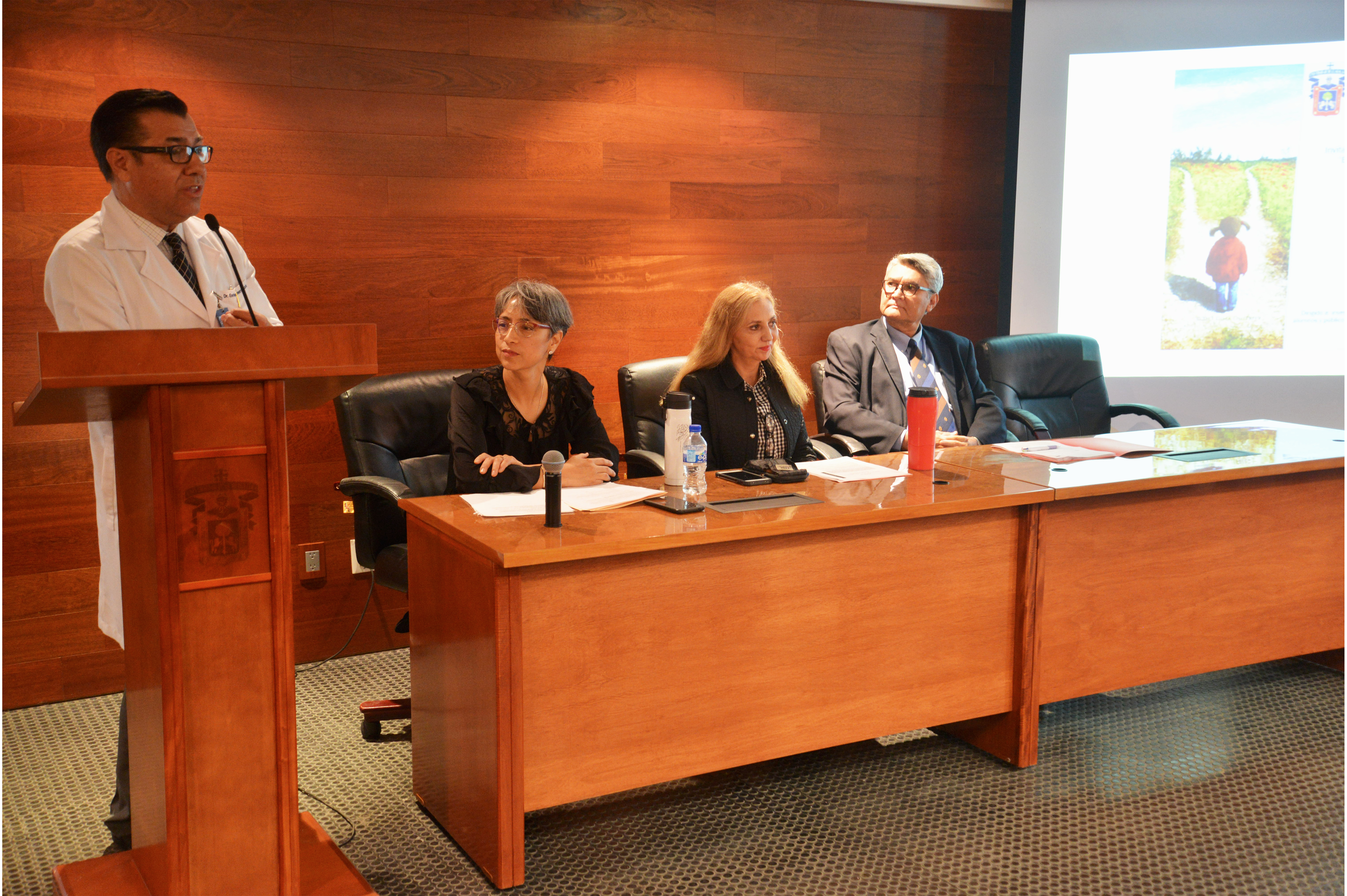 Dr. Enrique Velarde ofreciendo conferencia y miembros del presídium 