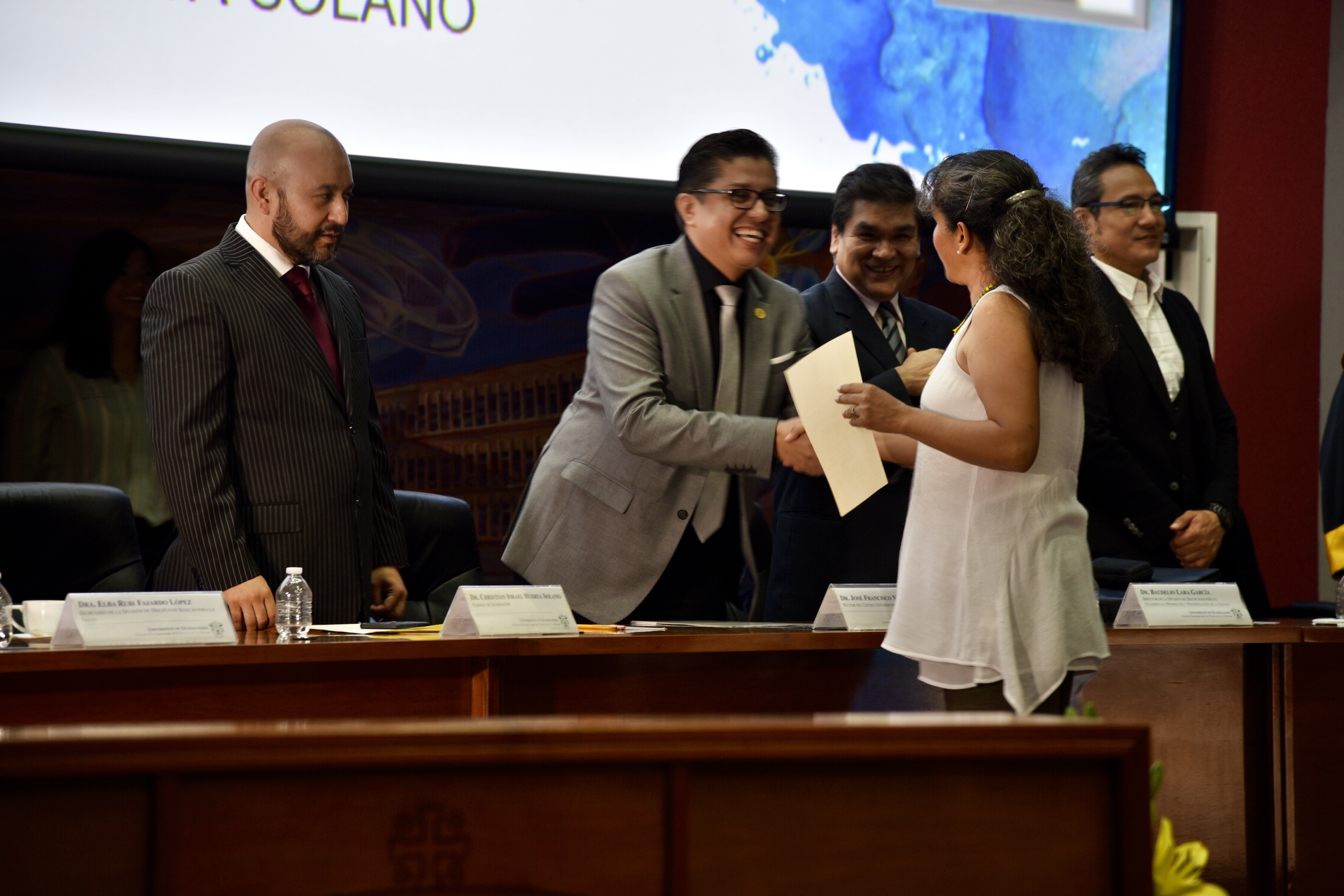 Rector de CUCS entregando reconocimiento a académica