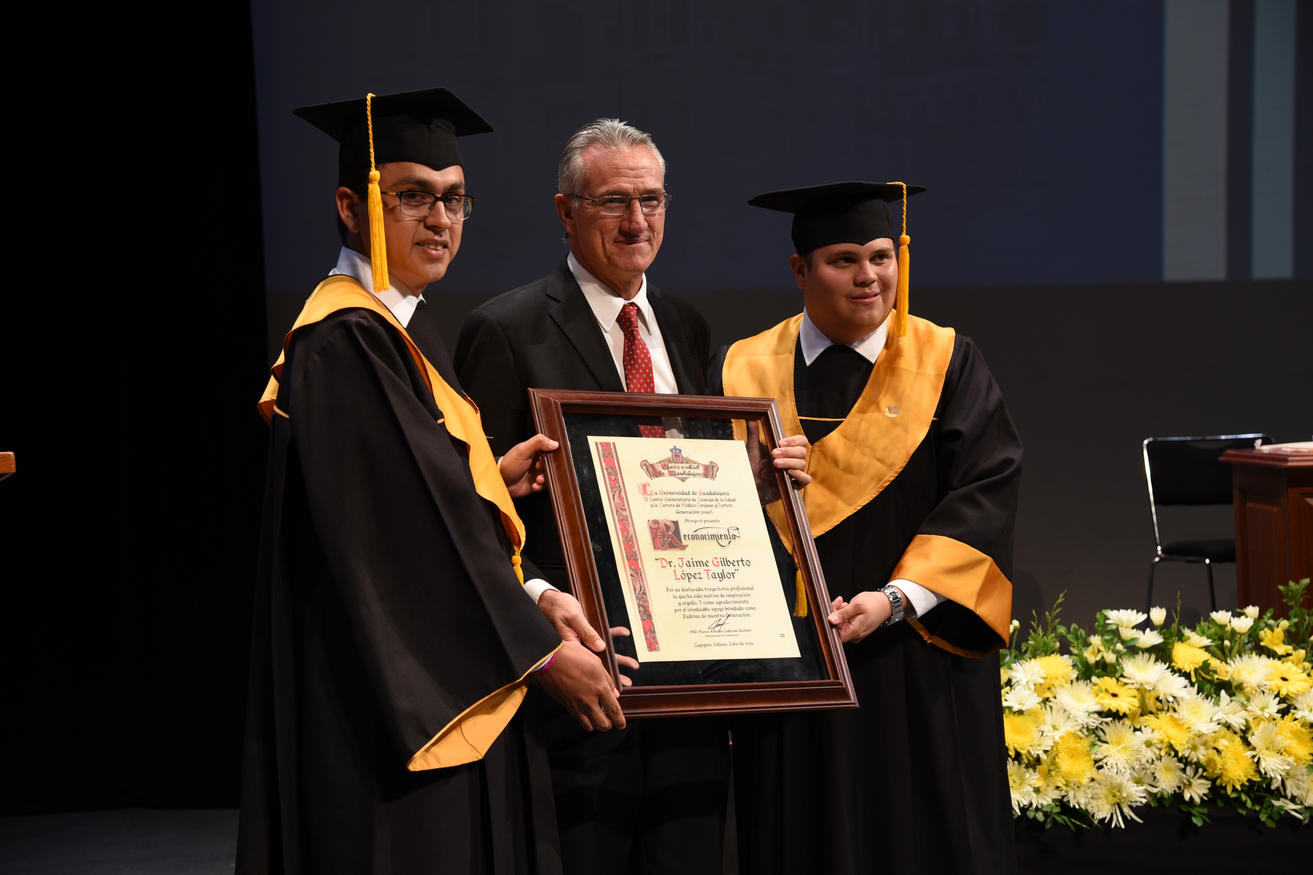 Alumnos entregando reconocimiento a padrino de generación