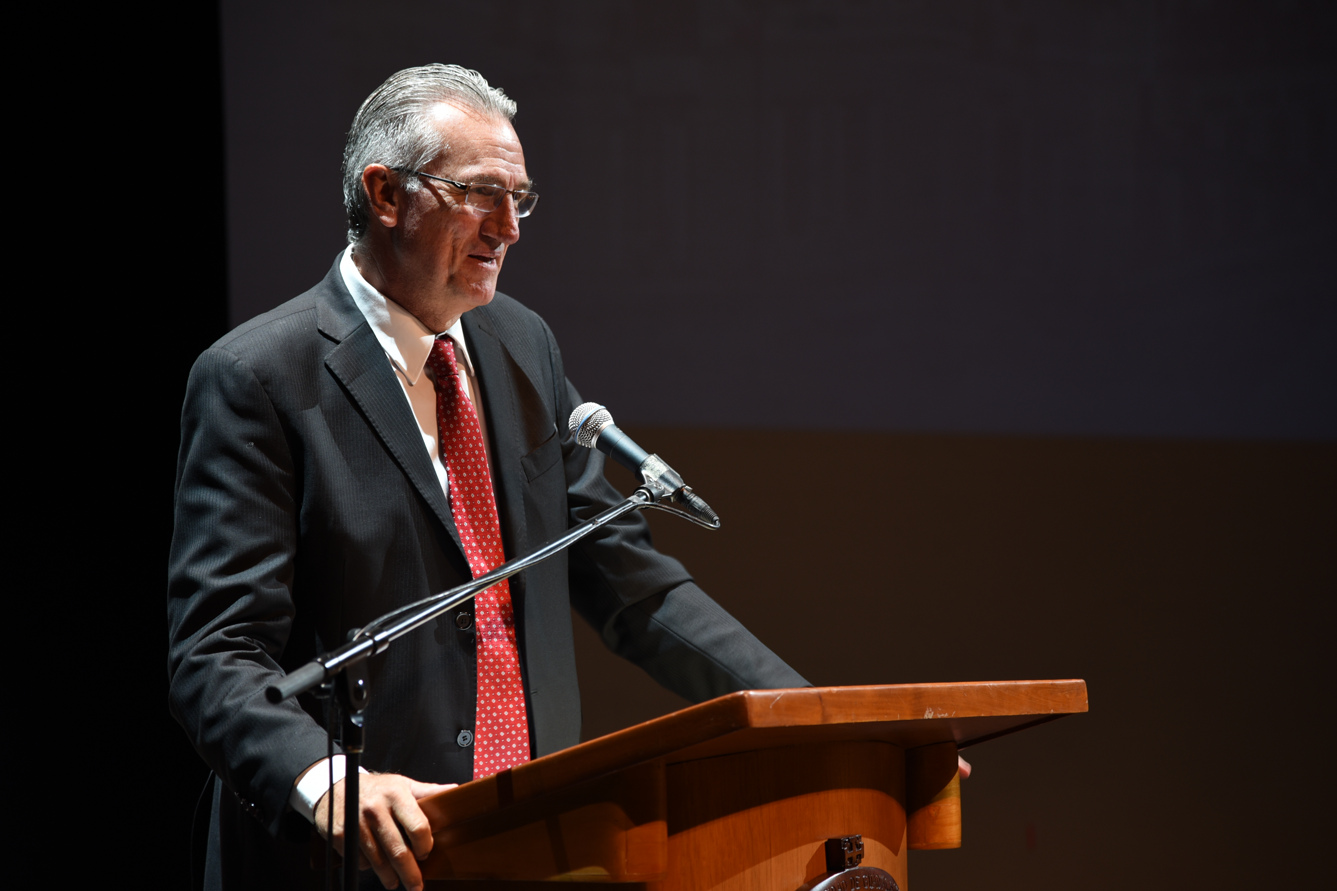 Padrino de Generación ofreciendo discurso a ahijados en el pódium
