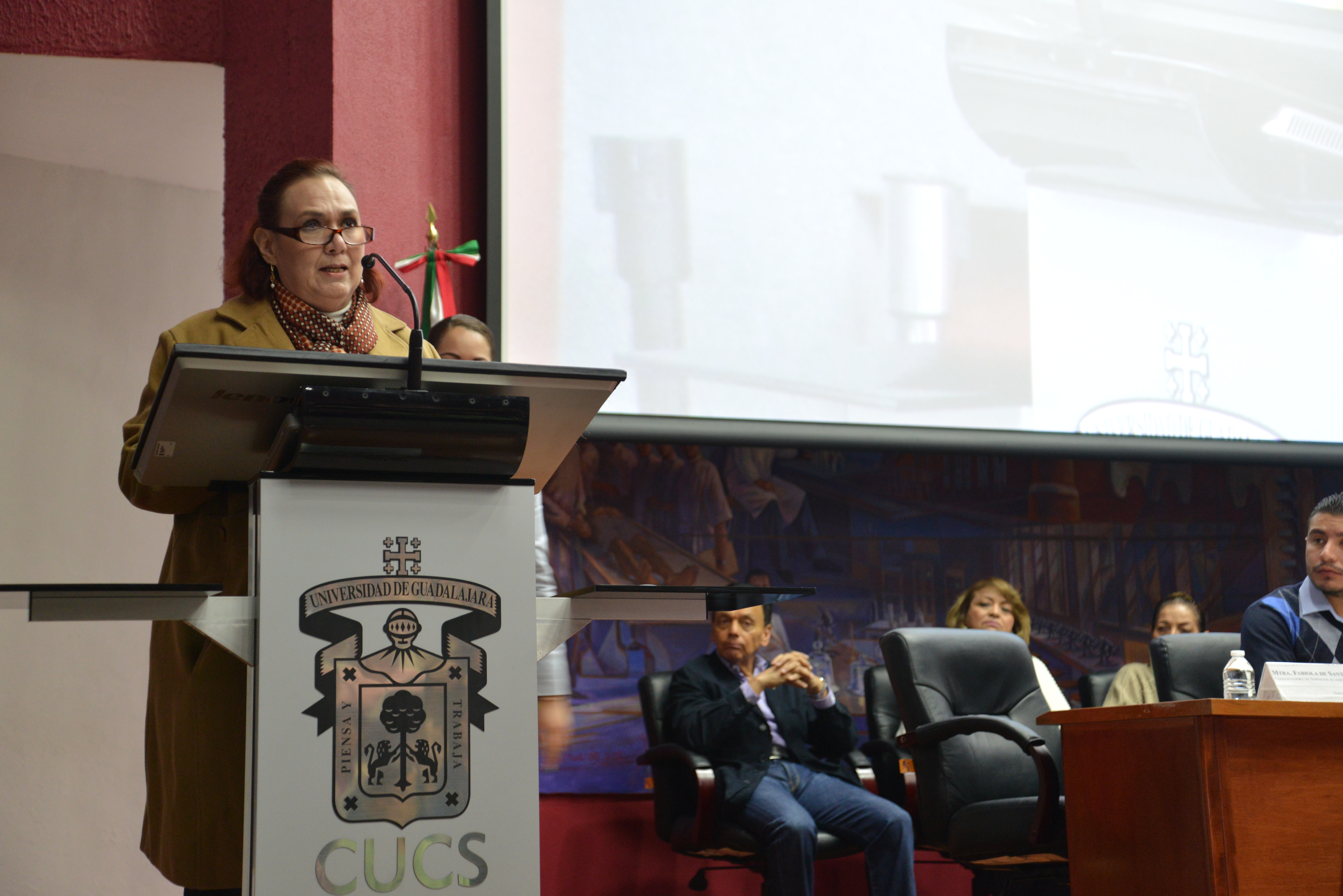 Mtra Fabiola de Santos, dando la bienvenida y presentando a los miembros del presiídium