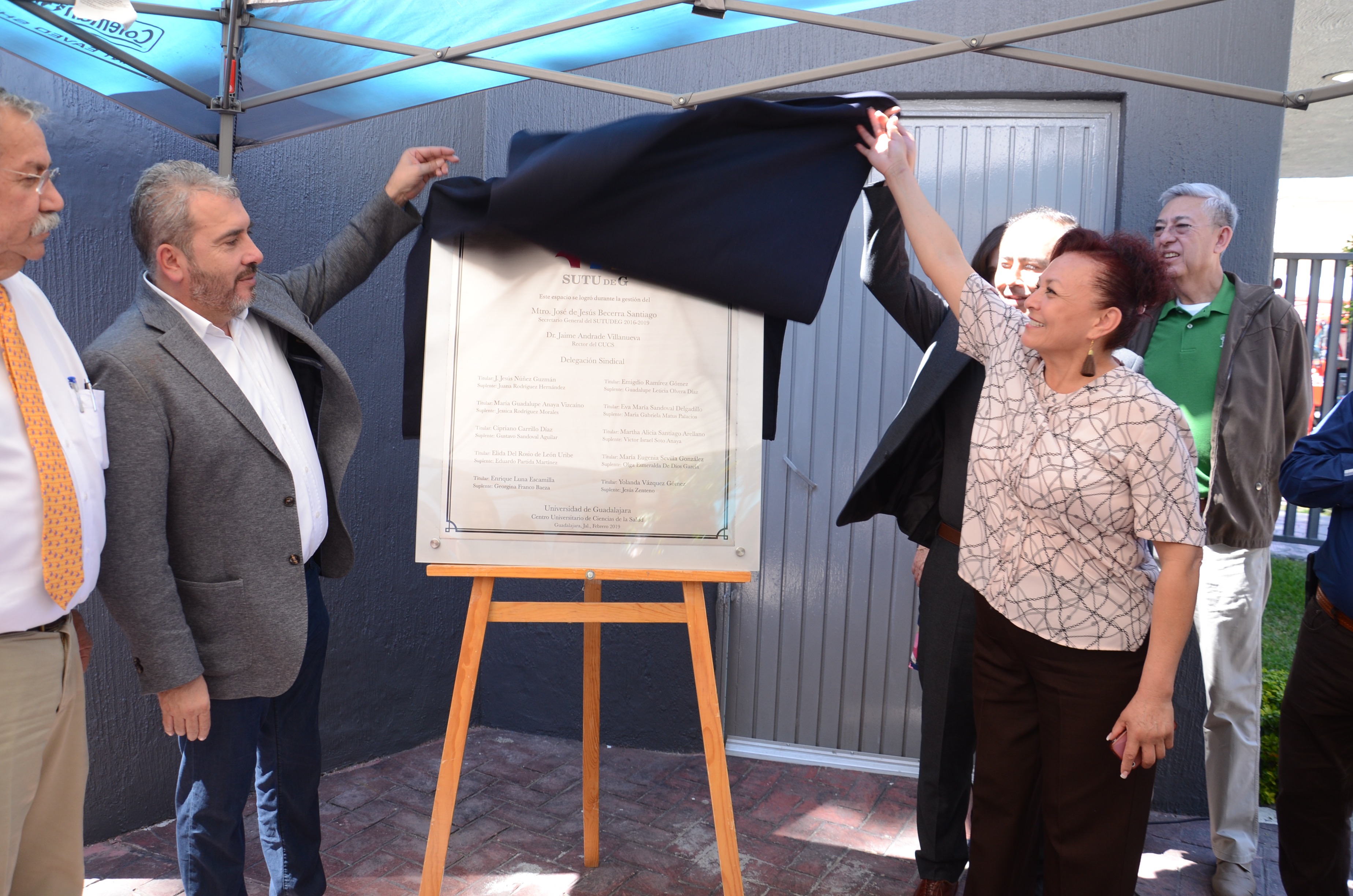 Secretario General y trabajadora del CUCS develando placa