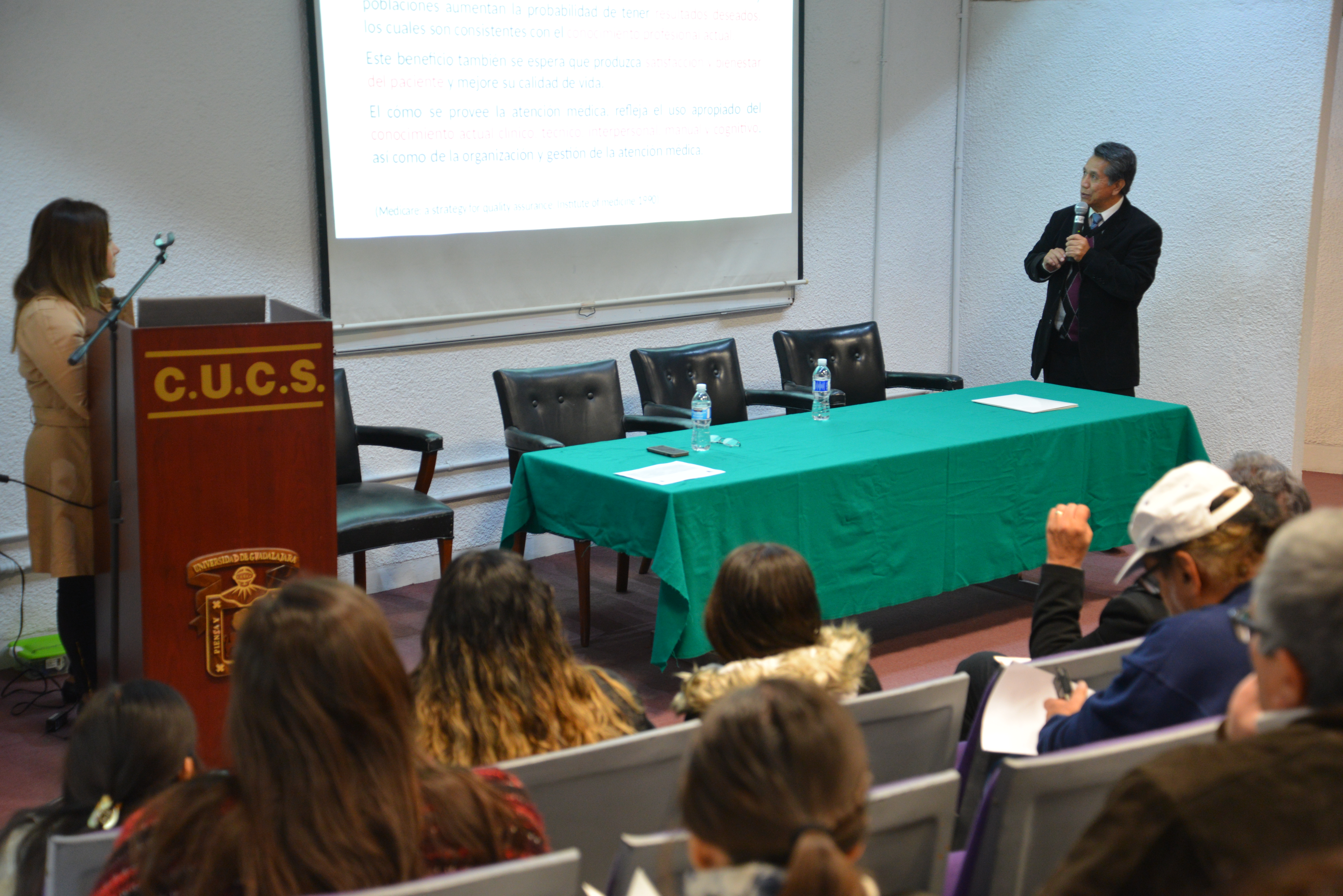 Dr. Noé Alfaro a un extremo del  podio dictando su conferencia y la Dra. Jéssica Nicolás del otro lado del podio