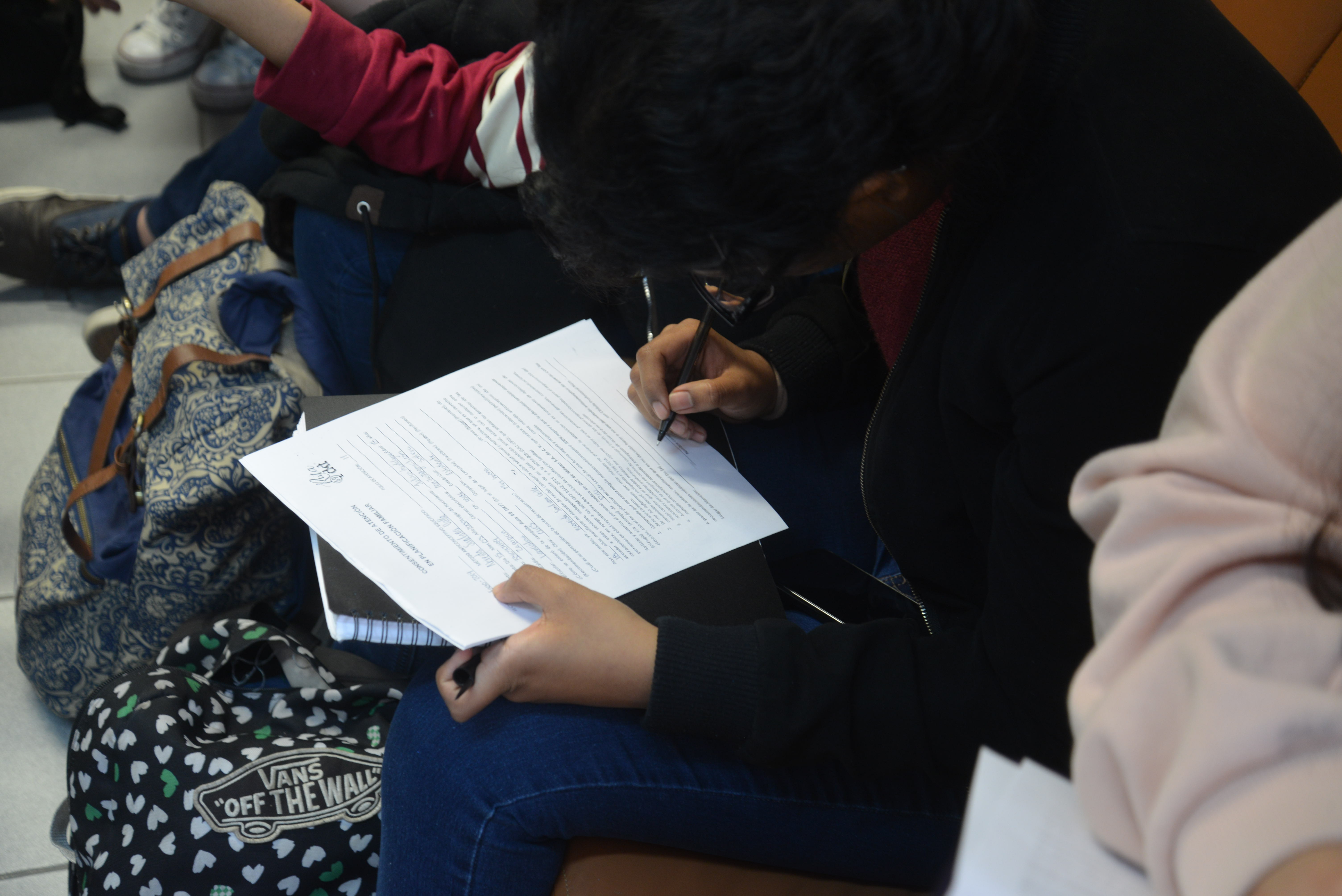 Alumna llenando formulario en el consultorio