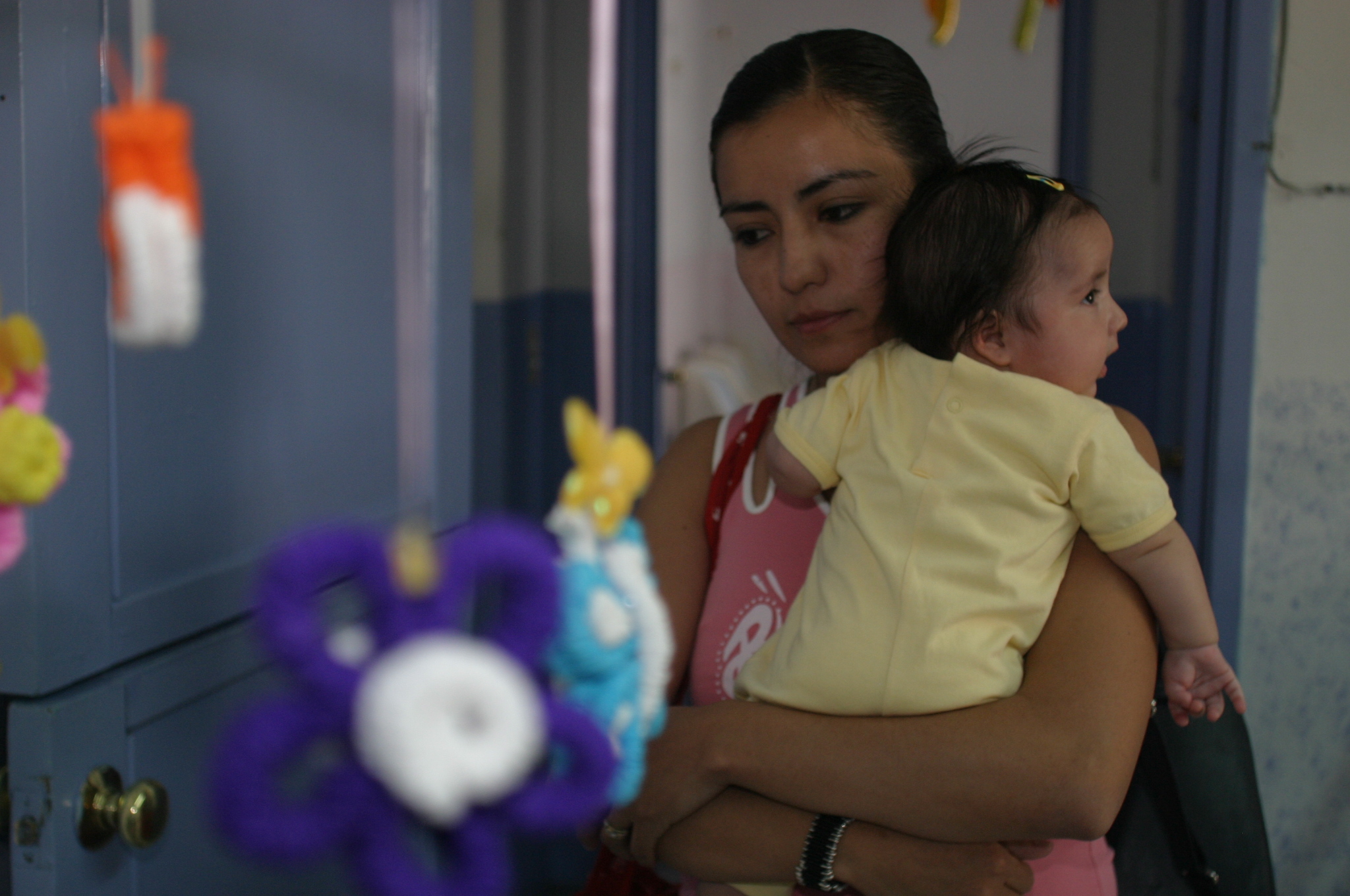 Imagen de una madre cargando a su bebé en una guardería