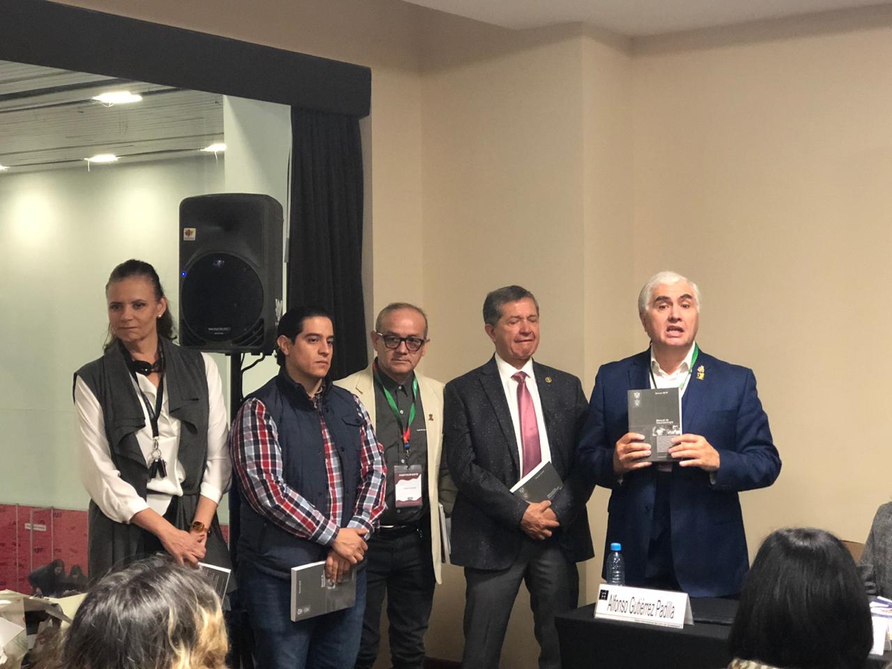 Dr. José Antonio Gutiérrez Padilla al micrófono rodeado de sus colaboradores