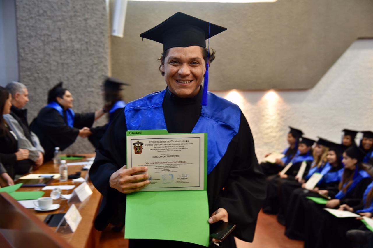 Alumno graduado sonriente mostrando su constancia de terminación