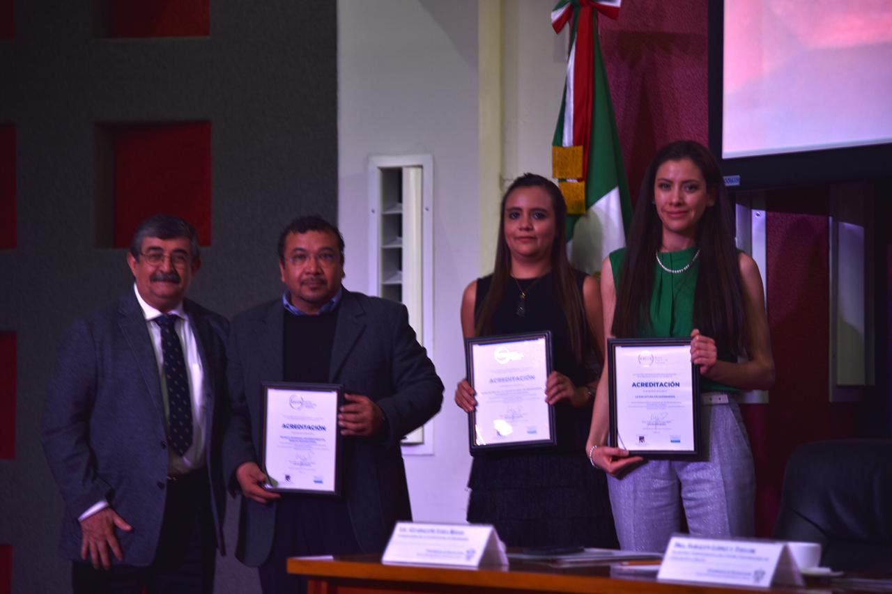 Foto grupal de los coordinadores de carrera acreditados exhibiendo el reconocimiento