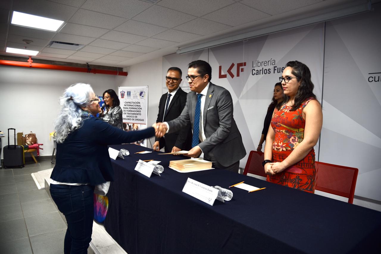 Rector del CUCS entregando reconocimiento a académica 