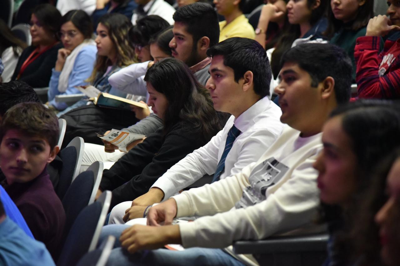 Alumnos con bata blanca atentos a la conferencia