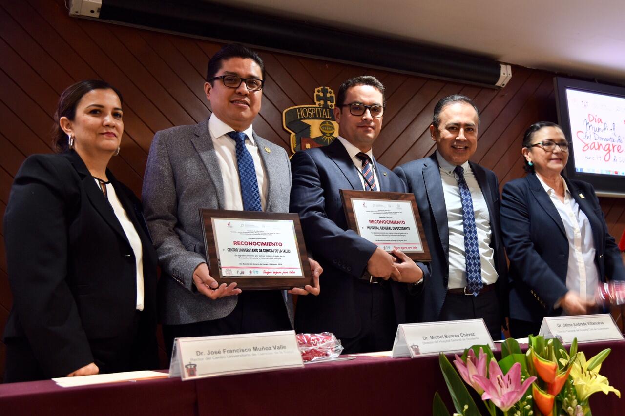 Dr. Muñoz posando con reconocimiento en mano acompañado de otros rectores