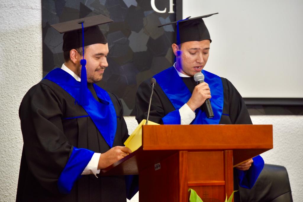 Representantes de generación en pódium dirigiendo mensaje graduados