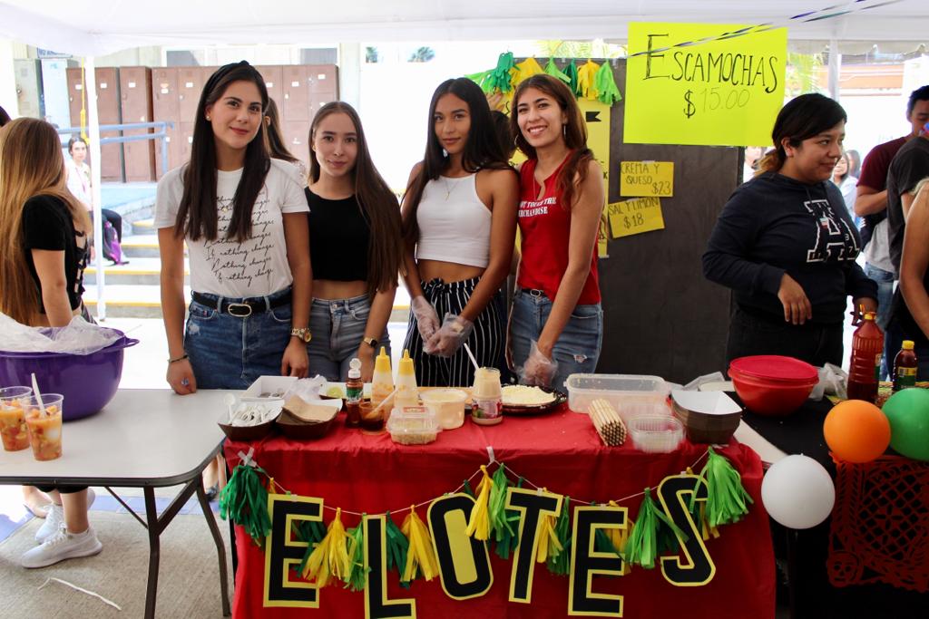 Alumnos atendiendo stand de aguas frescas