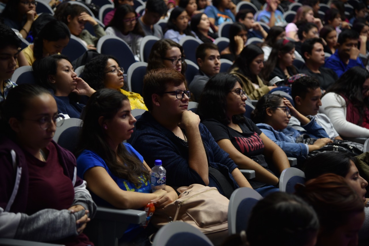 Alumnos atentos a la conferencia en auditorio lleno