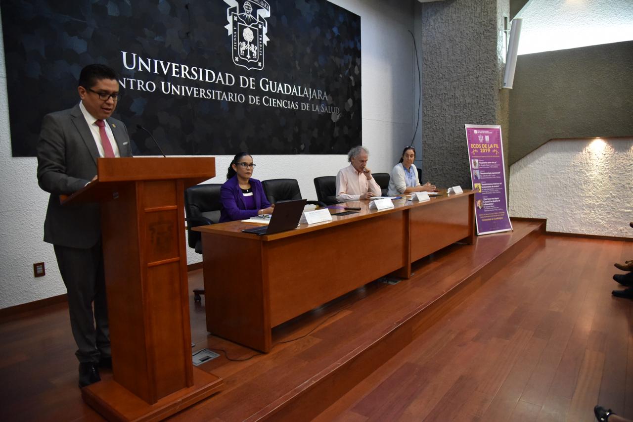 Toma de costado, rector al micrófono, al fondo los miembros del presídium