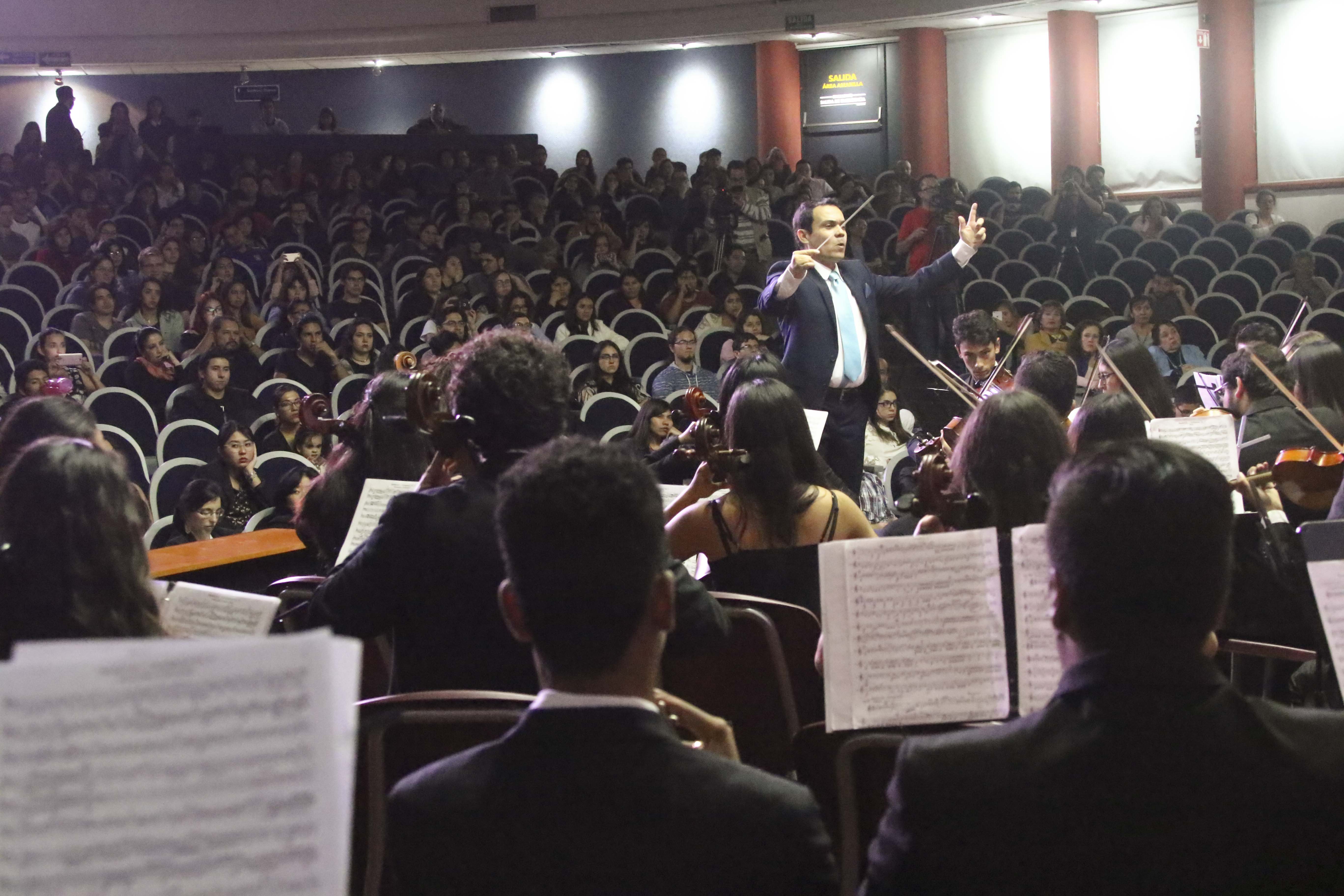 Músicos en pleno concierto. Director al fondo alzando la batuta